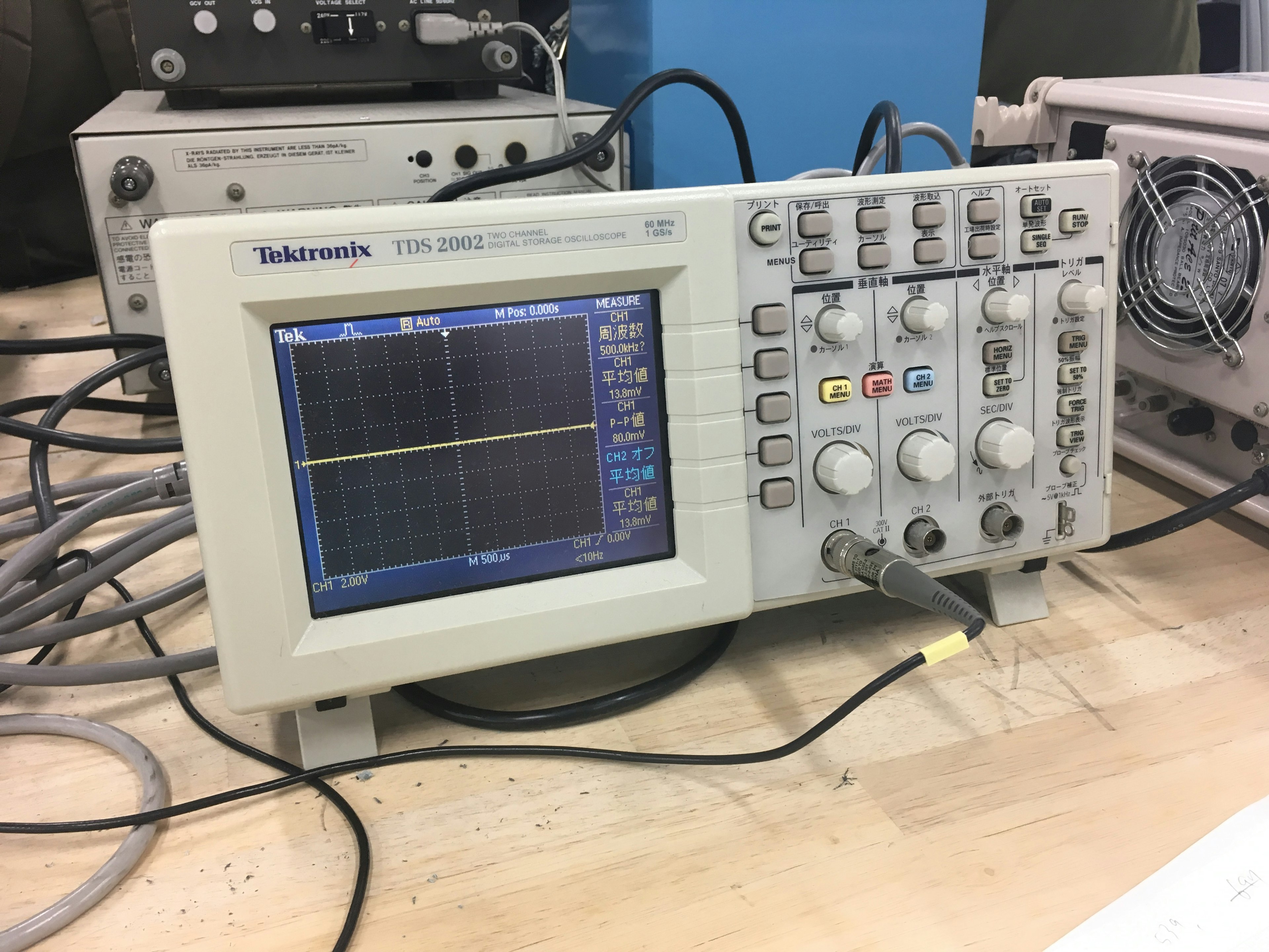 An oscilloscope on a workbench with various controls and connections