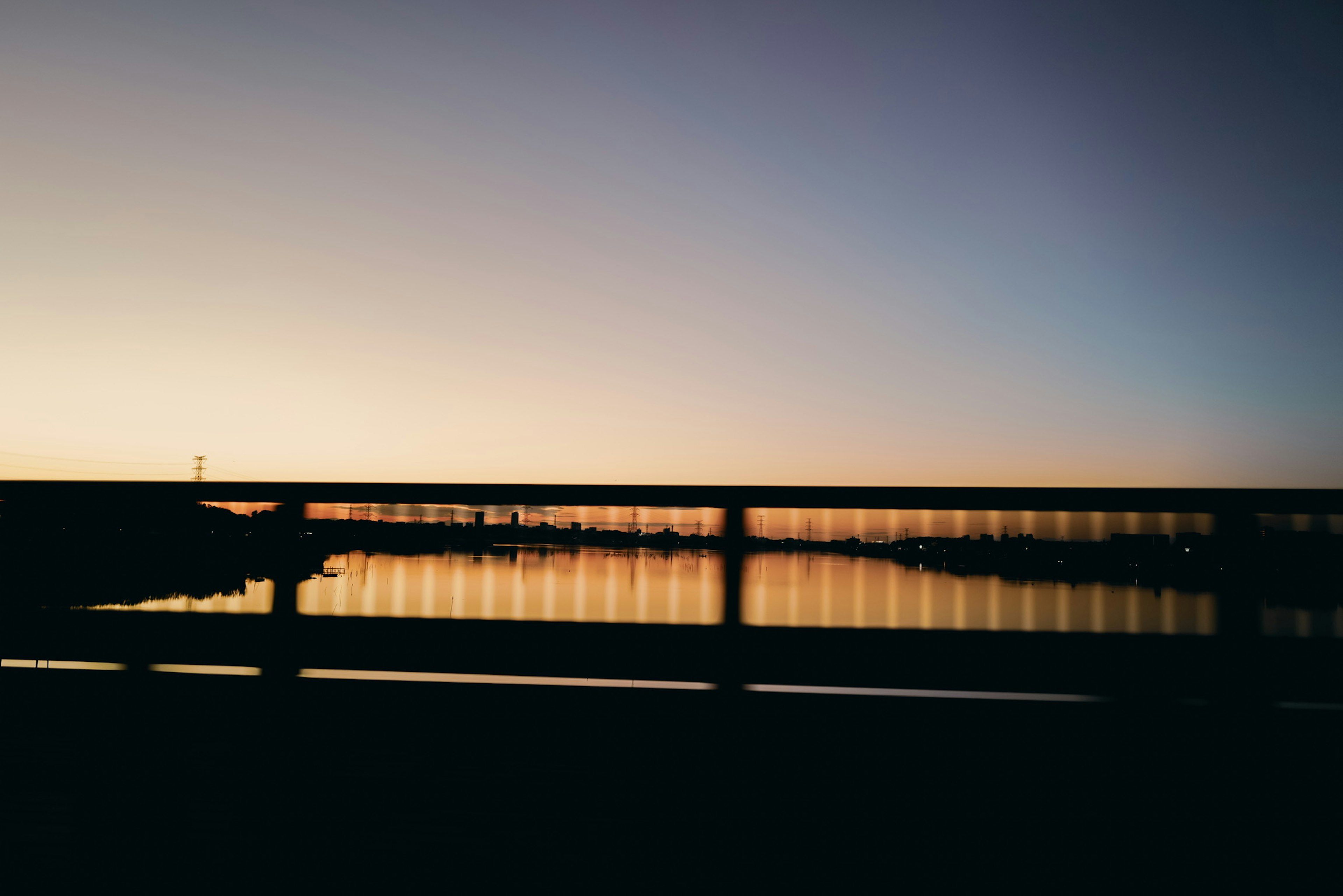 Bellissimo tramonto su un fiume con silhouette di un ponte