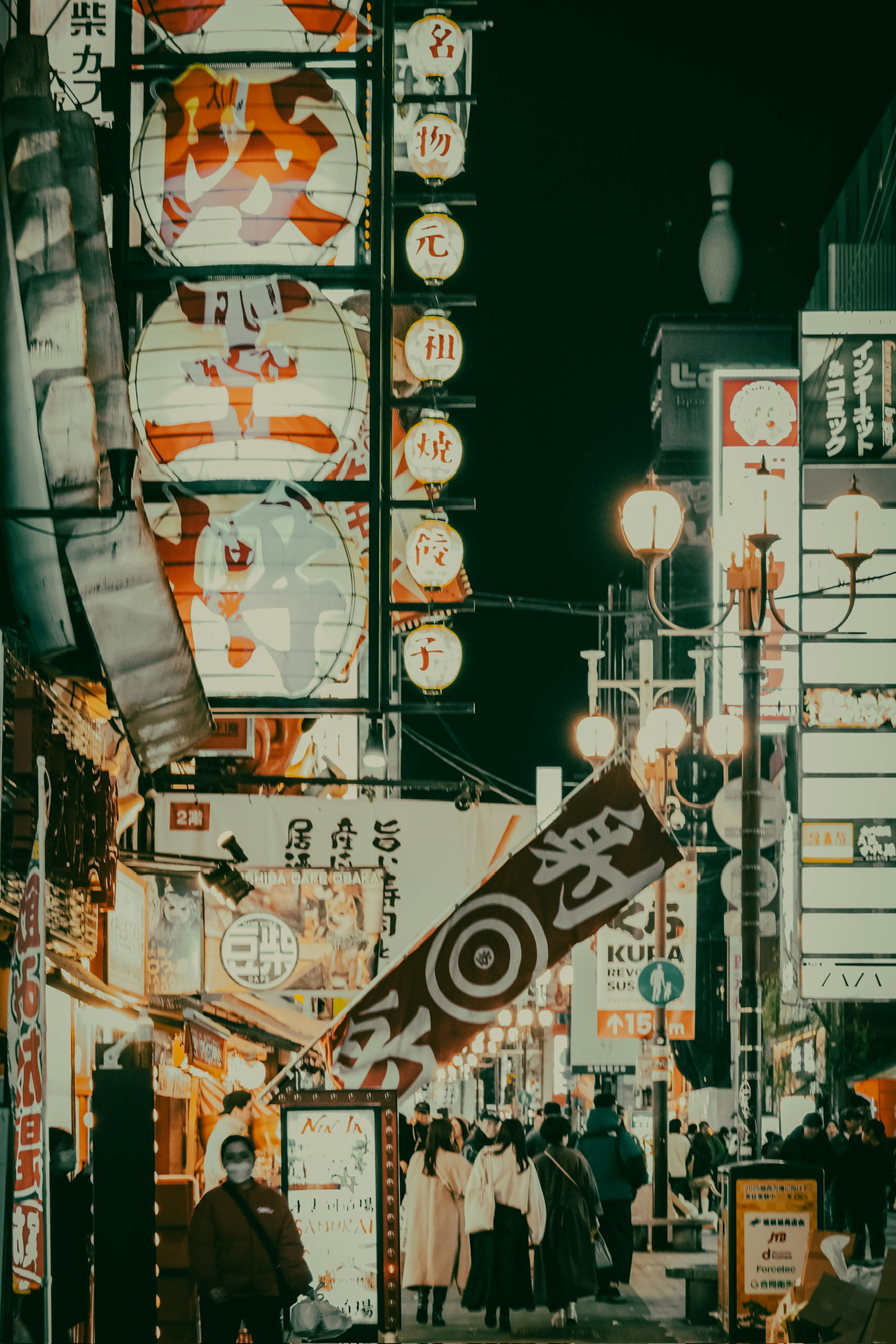 Vibrant city street at night with glowing neon signs and people