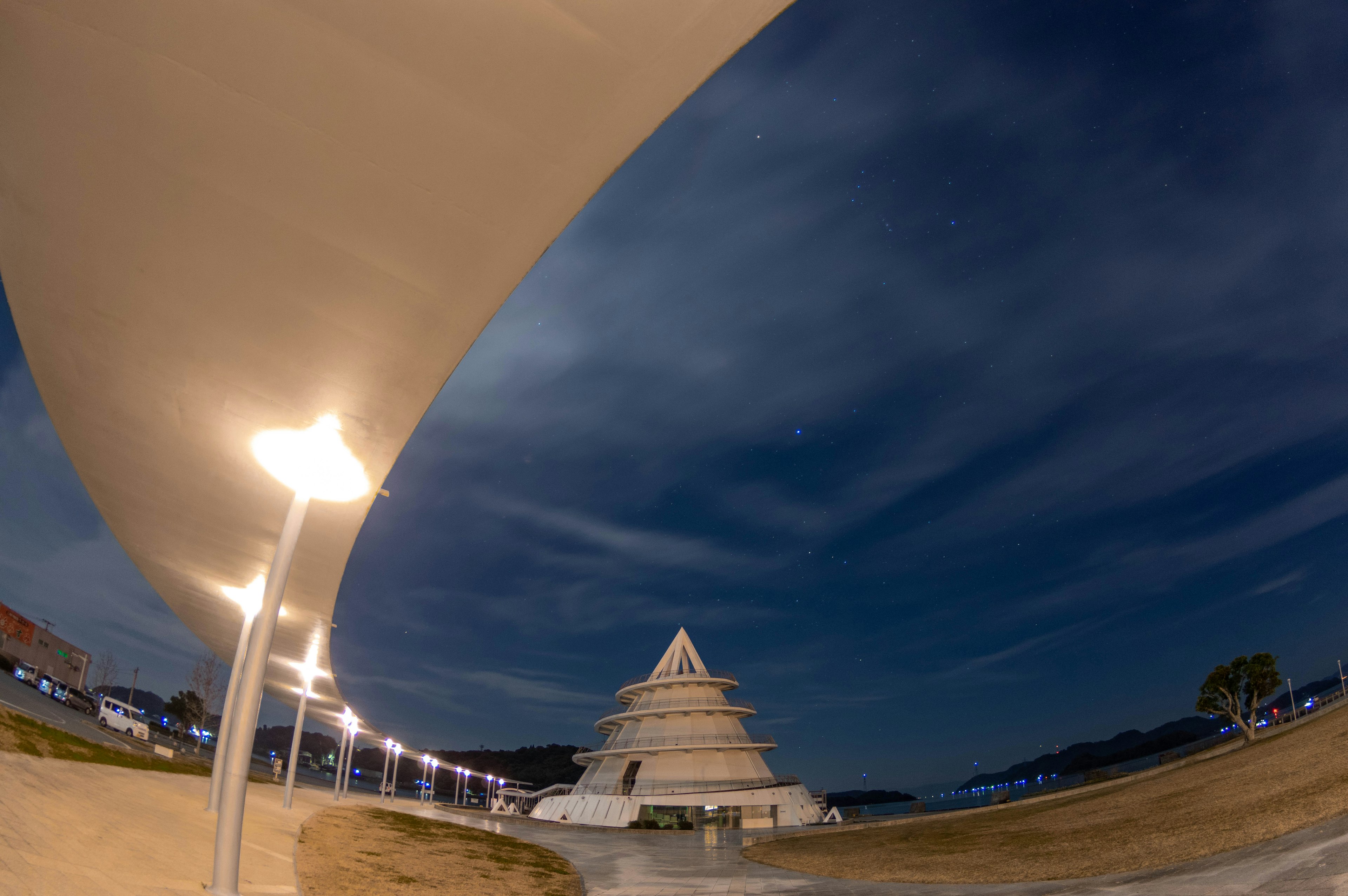 Edificio en forma de pirámide iluminado de noche bajo un cielo nublado