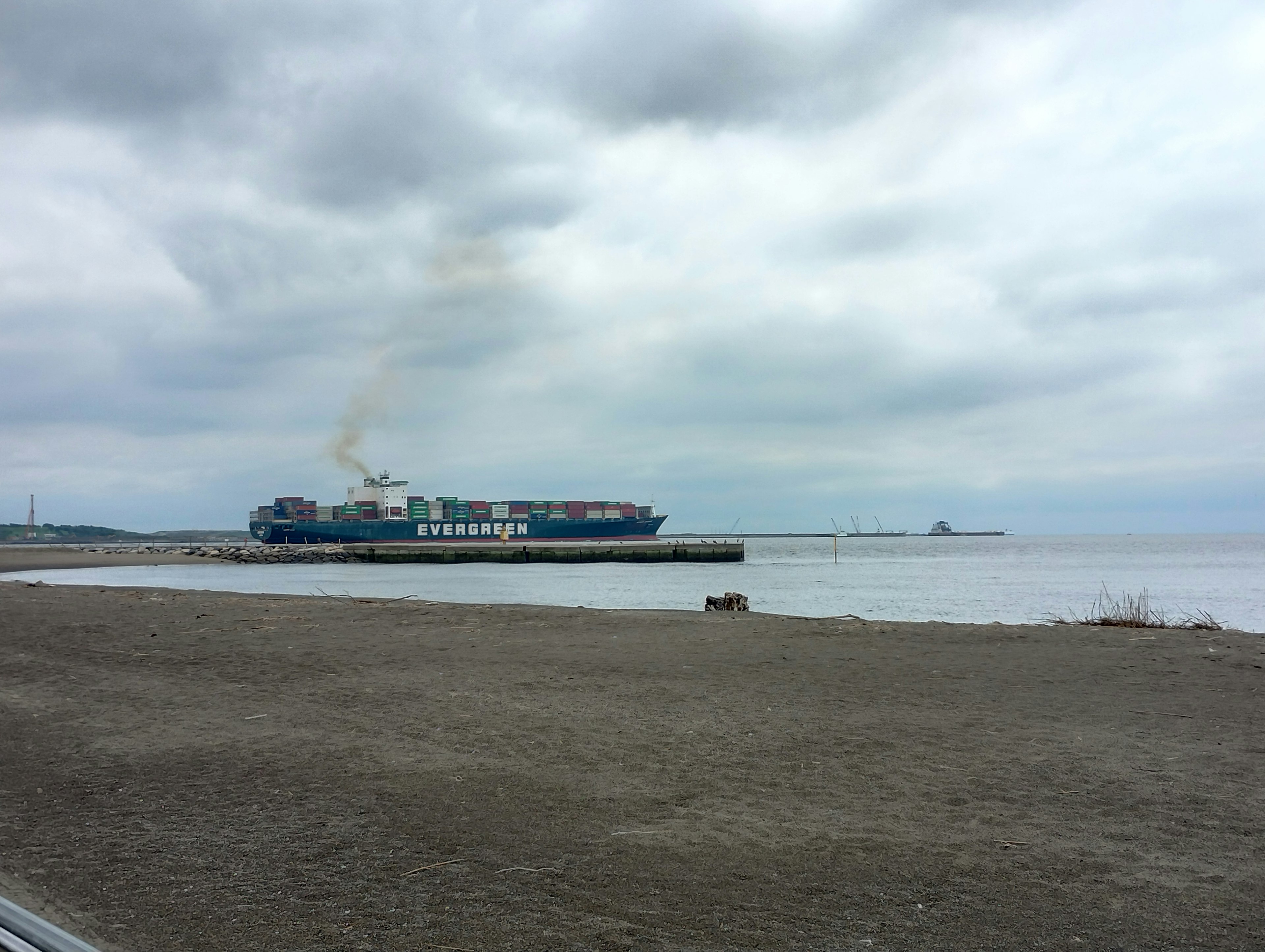 Freight ship docked near the shore under a cloudy sky