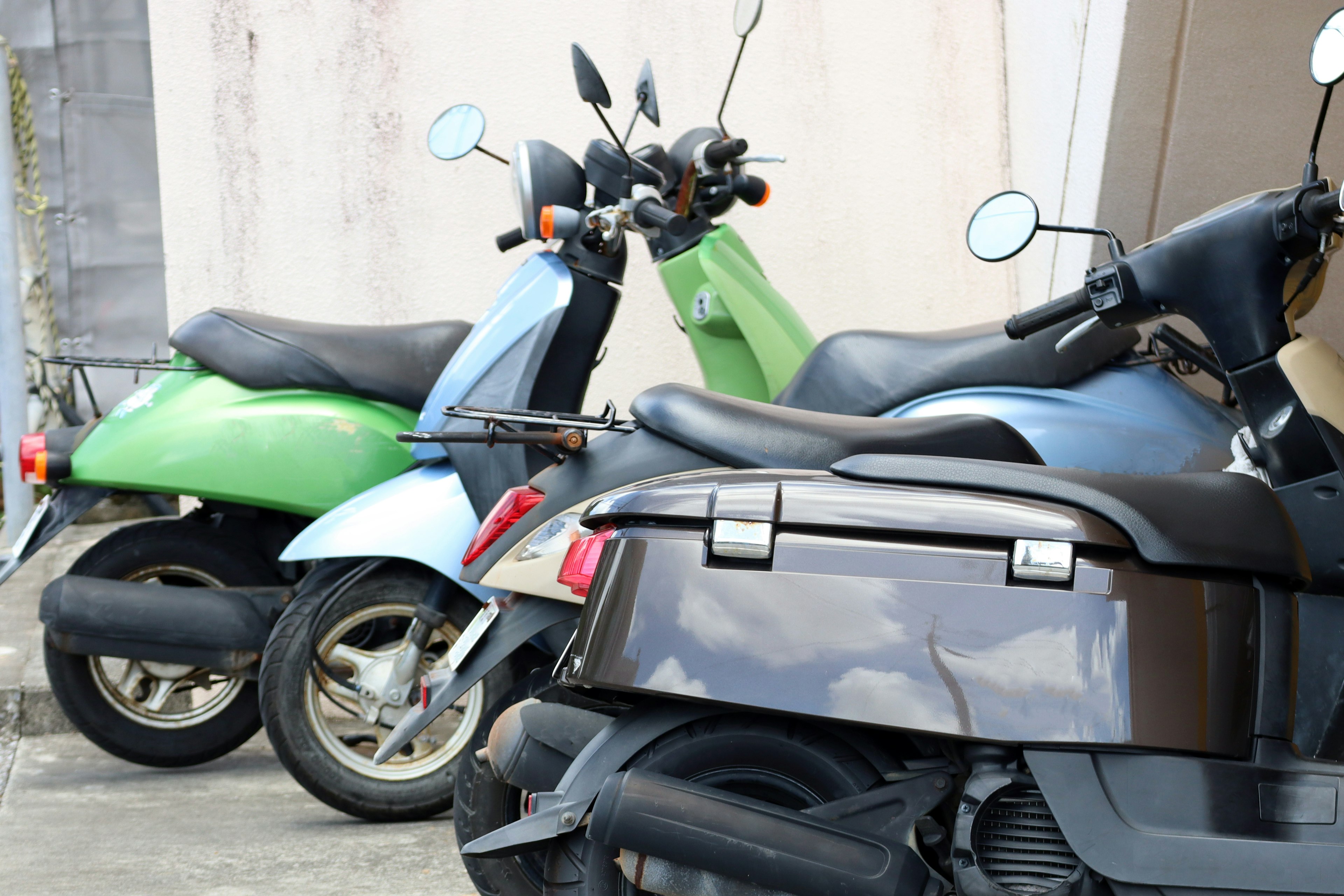 Image of green and blue scooters parked side by side