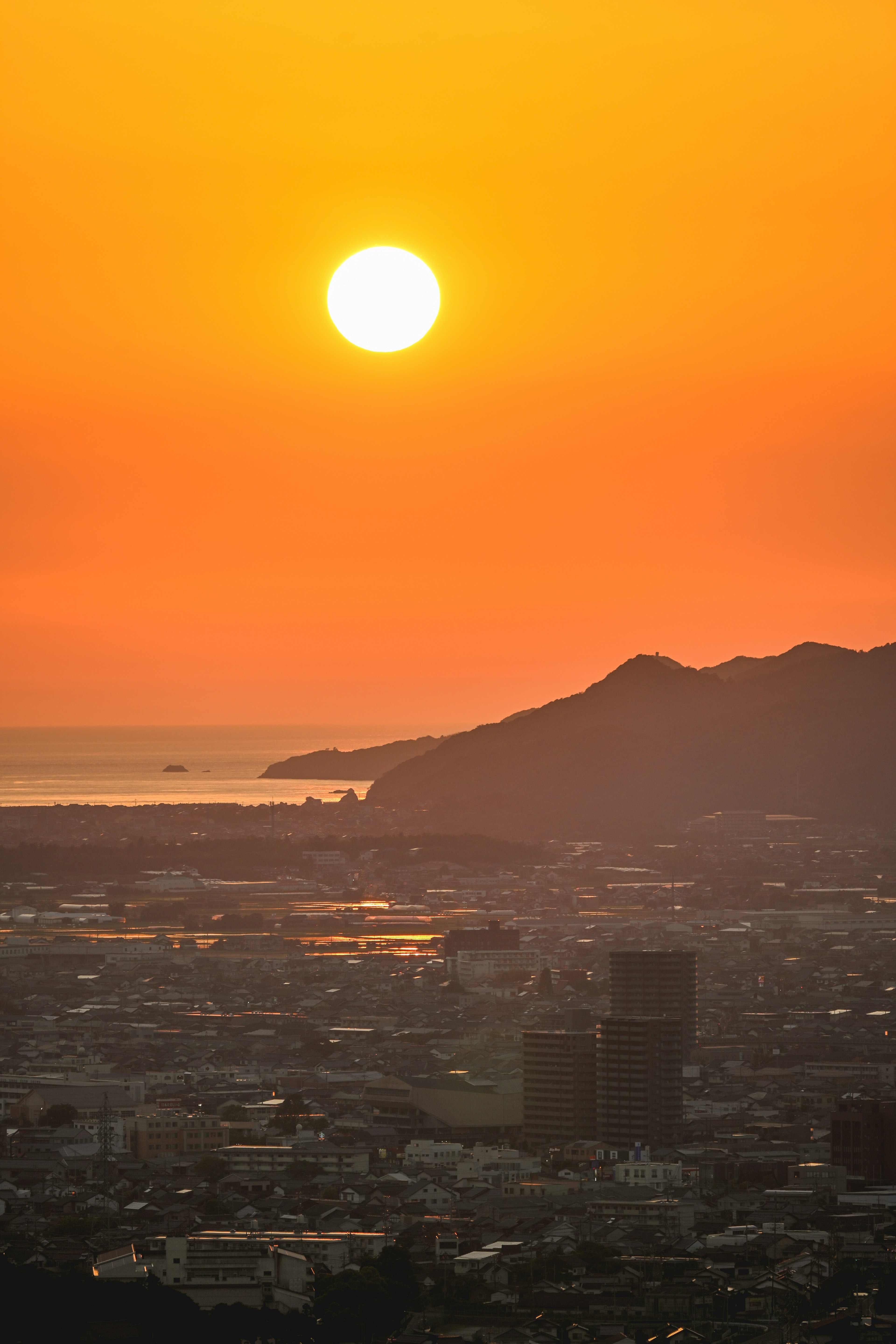 美しい夕日が海と山の間に沈む風景