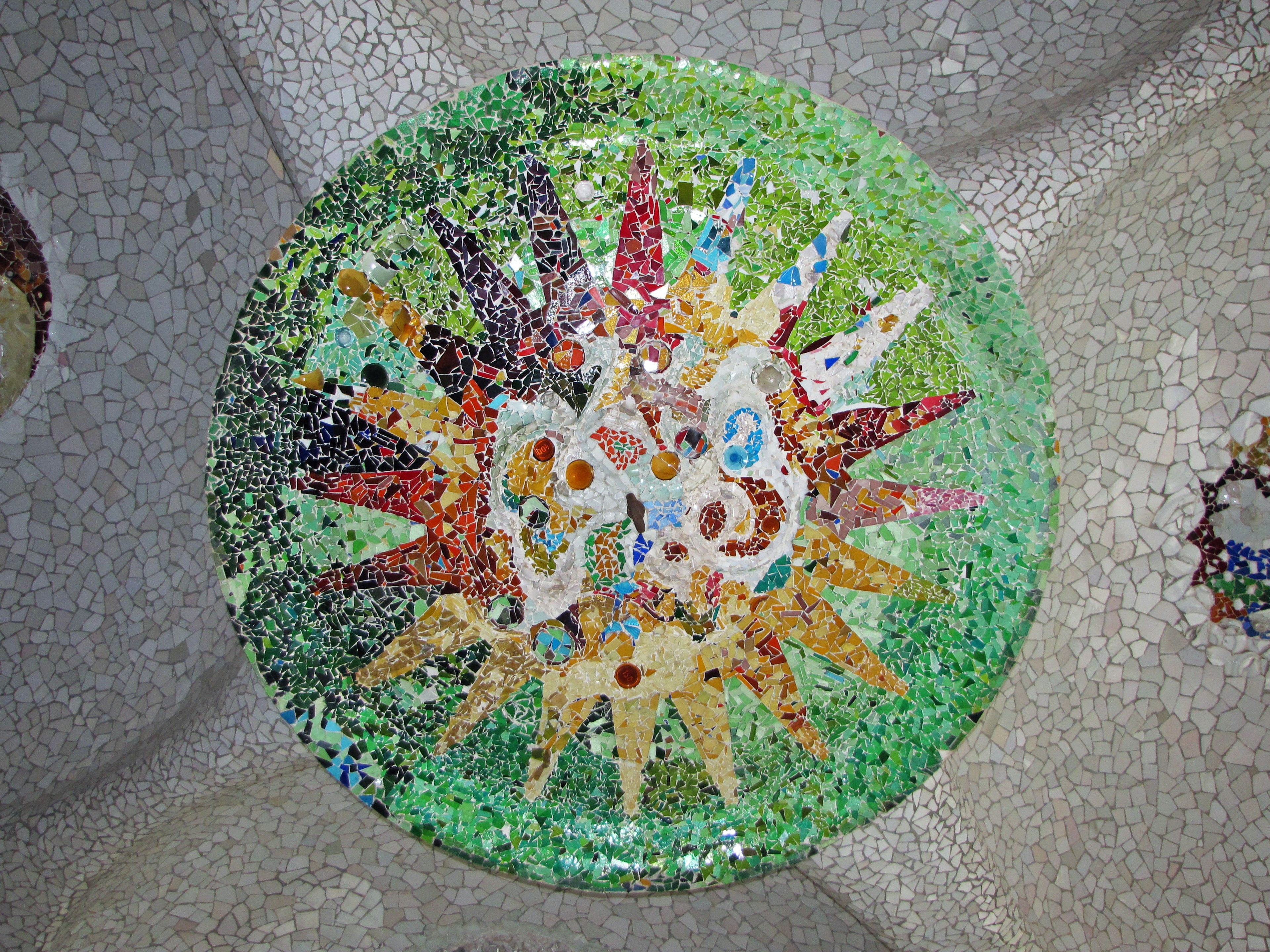 Circular mosaic design with colorful patterns on a green background