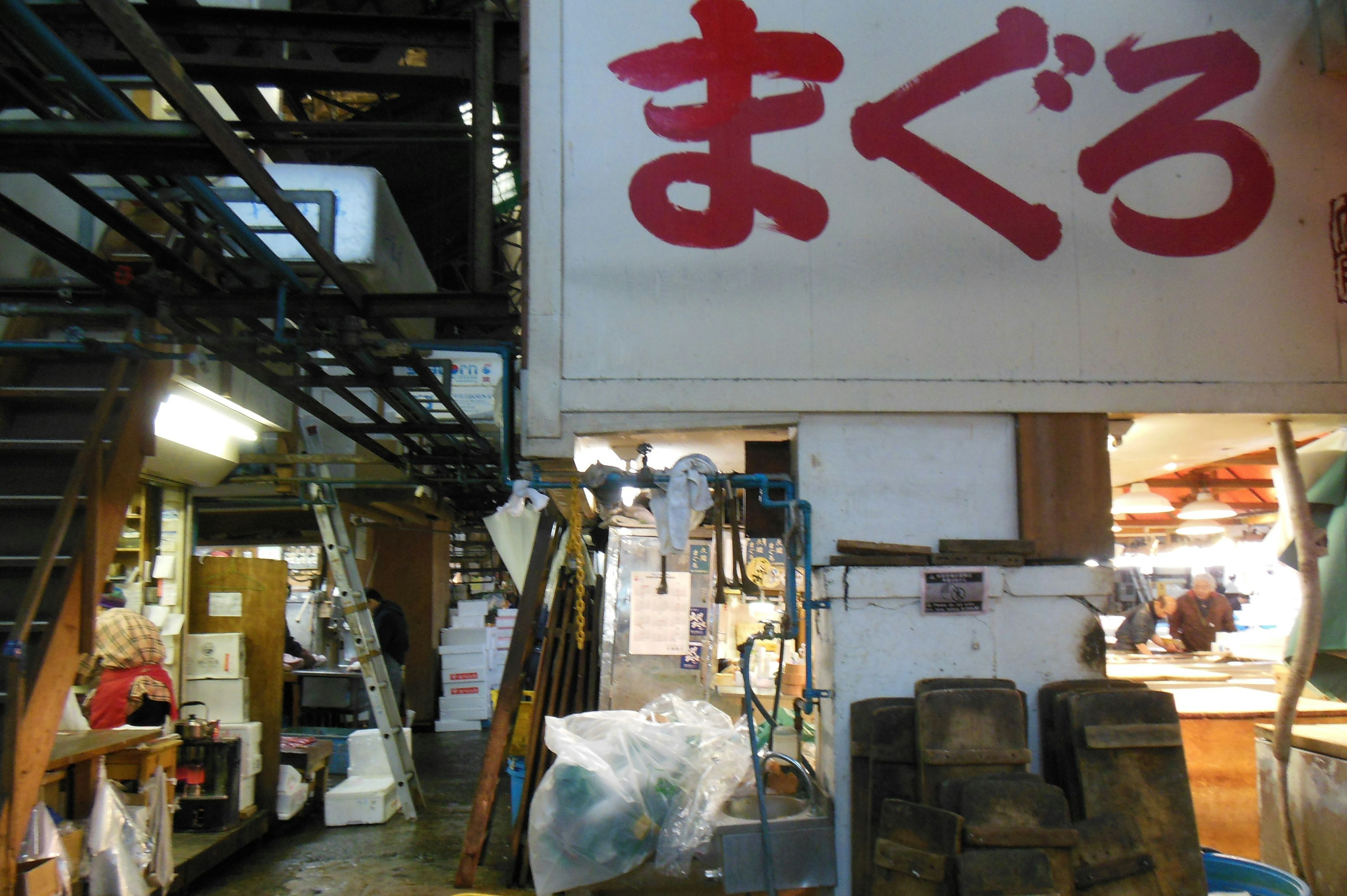 Intérieur d'un marché avec un panneau pour maguro et des objets environnants