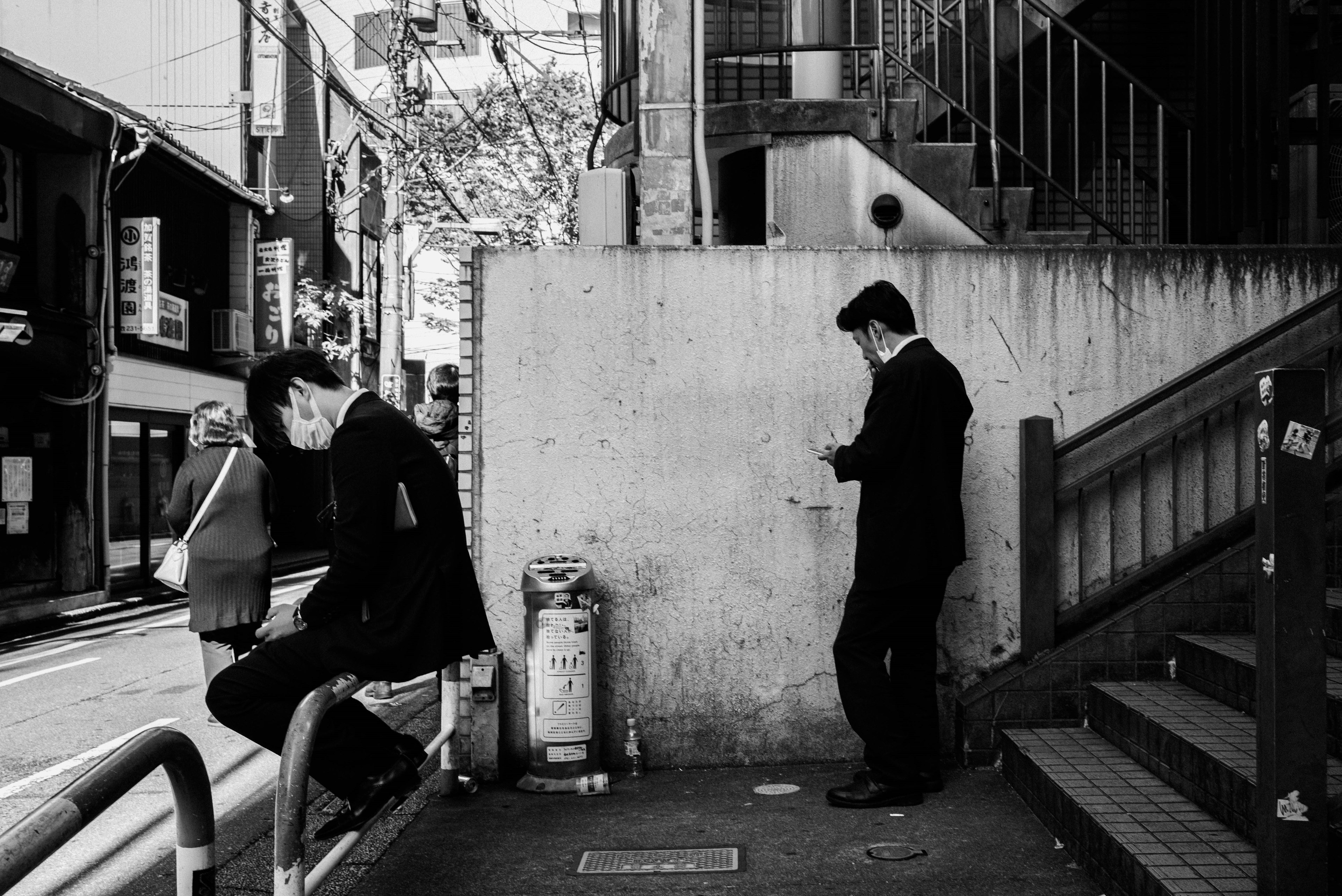 Two men in suits standing near stairs and railing in a black and white photograph