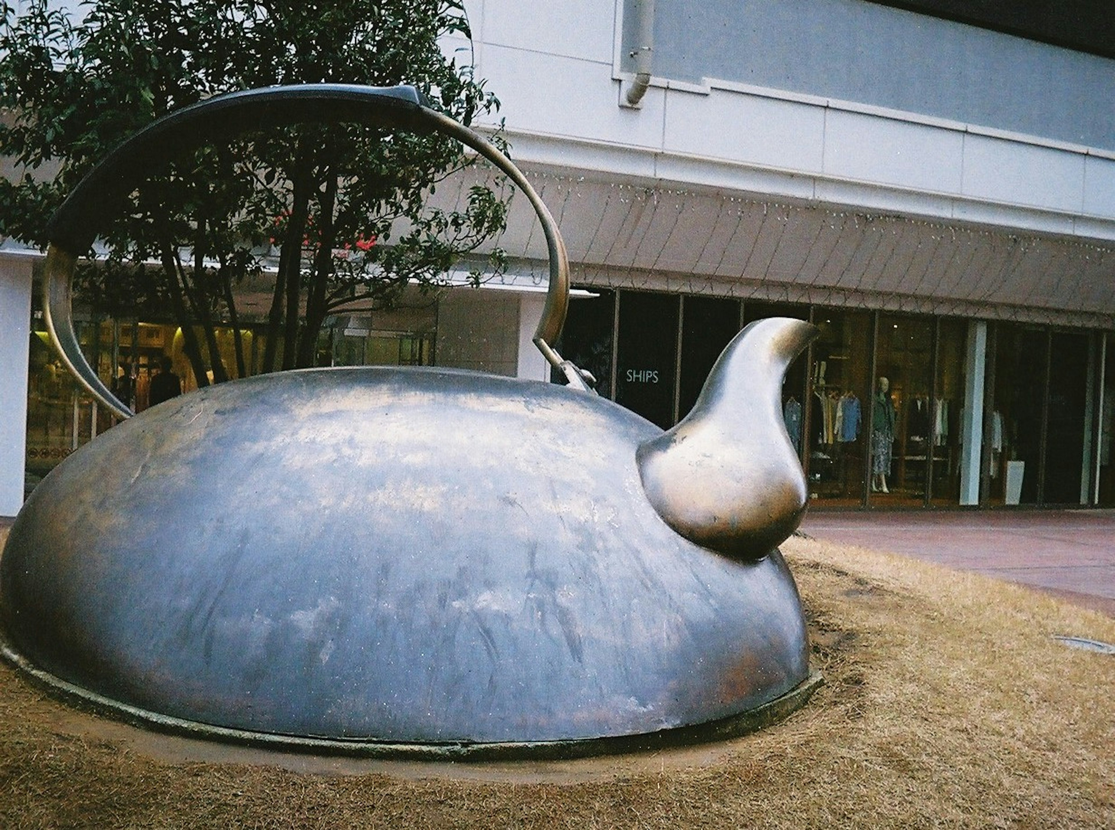 大きな金属製のティーポットの彫刻が展示されている風景