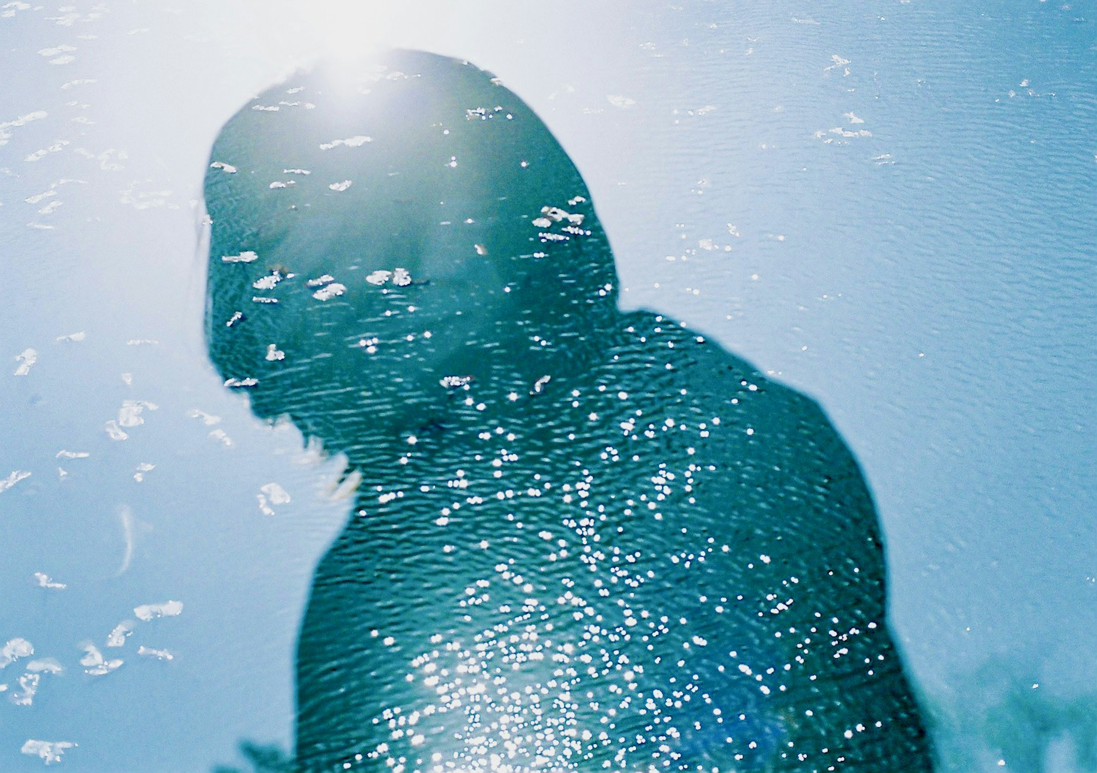 Silhouette of a person underwater with light reflections