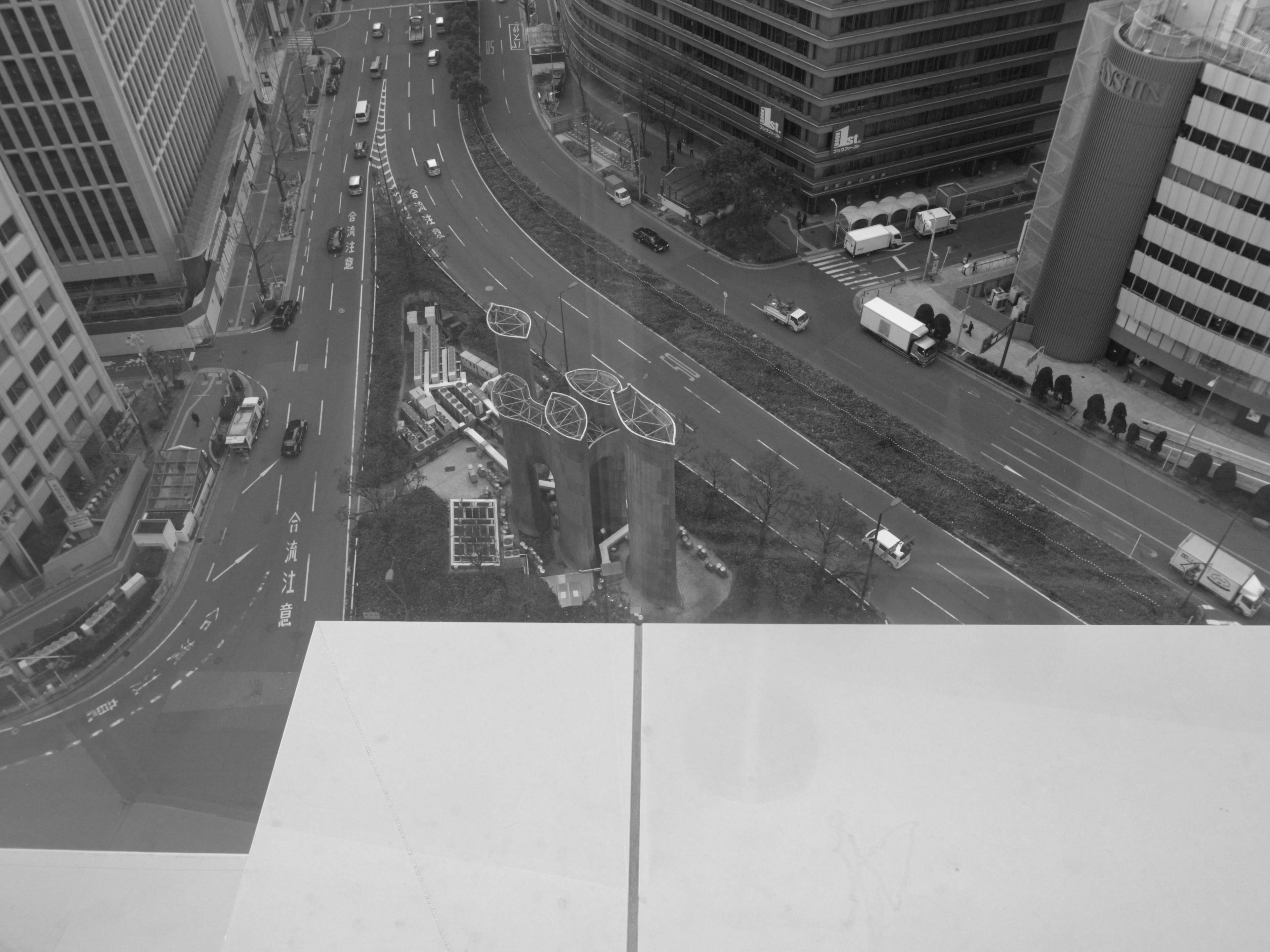 Luftaufnahme einer Stadtlandschaft von einem Hochhaus mit Straßen und Gebäuden in Schwarzweiß