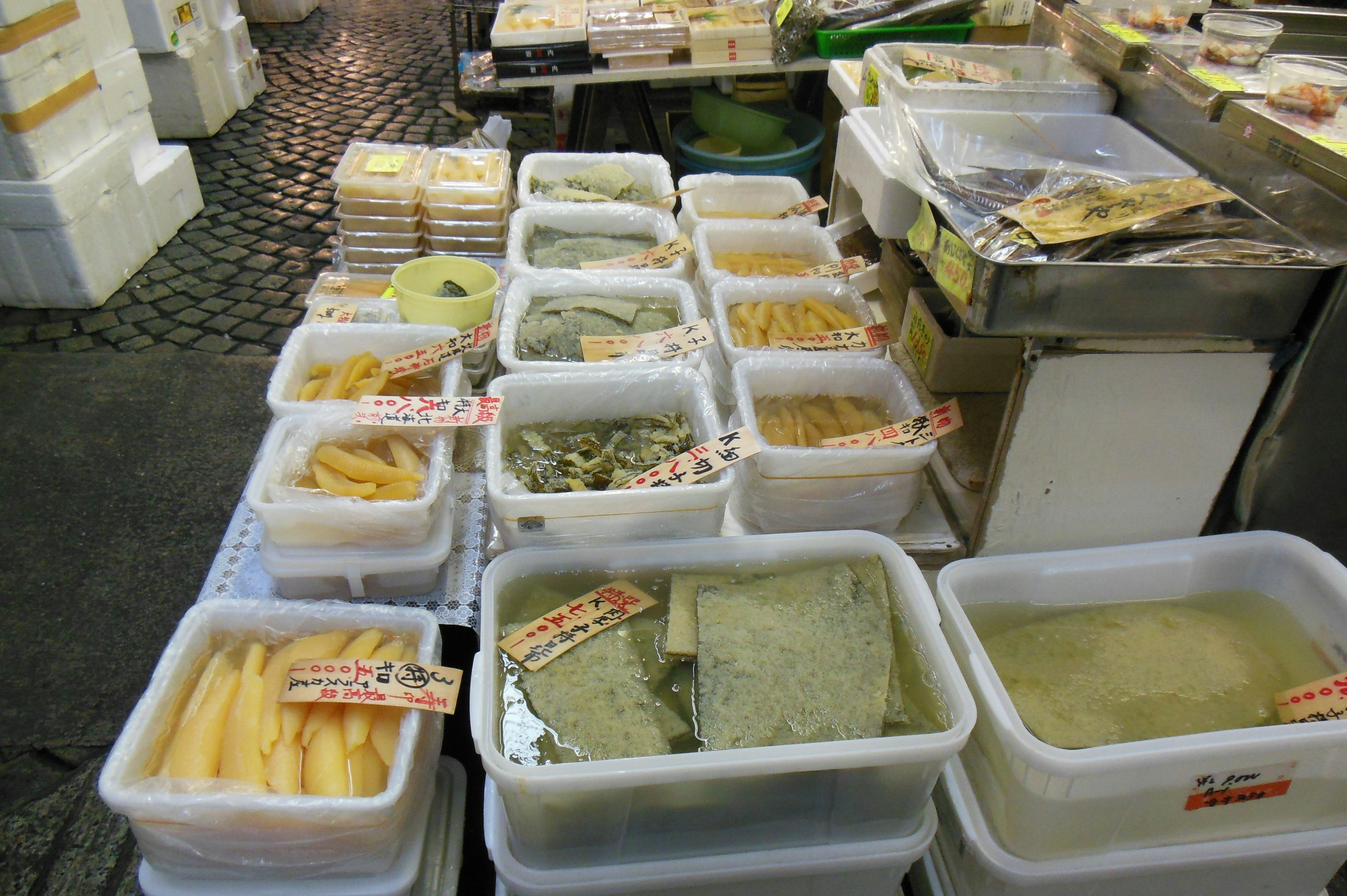 Transparent containers filled with various ingredients at a market stall