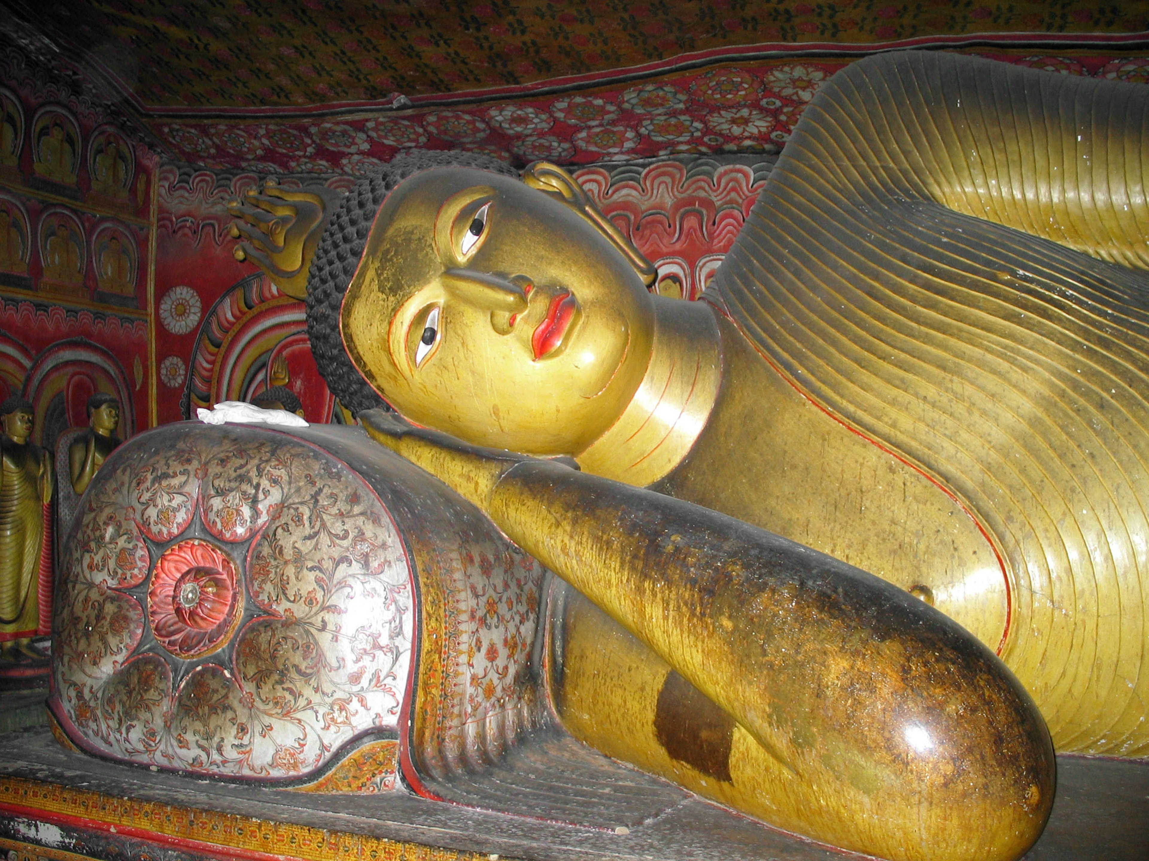 Reclining golden Buddha statue with detailed head and arm features