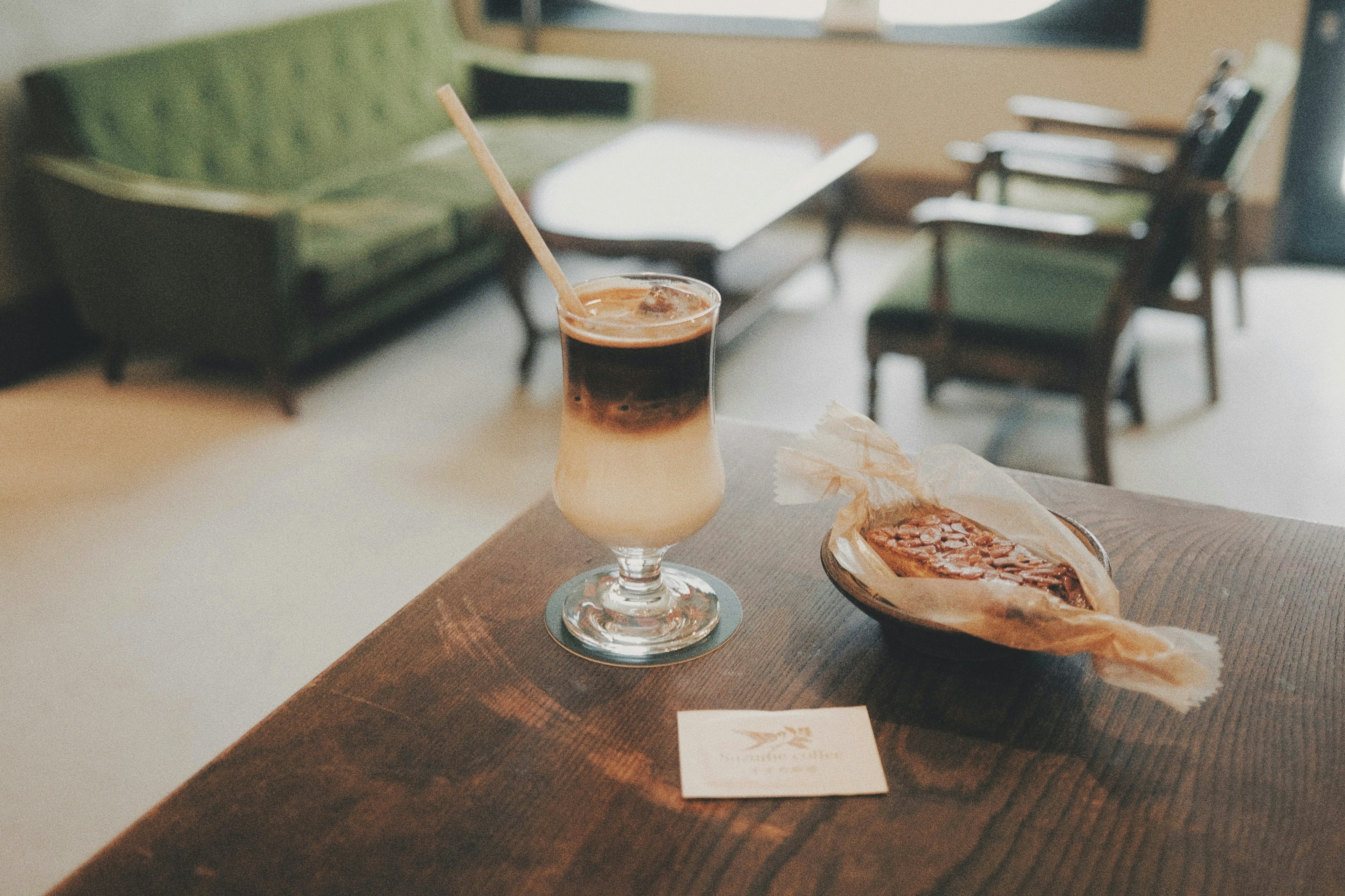 A stylish café setting featuring iced coffee and a pastry on a wooden table