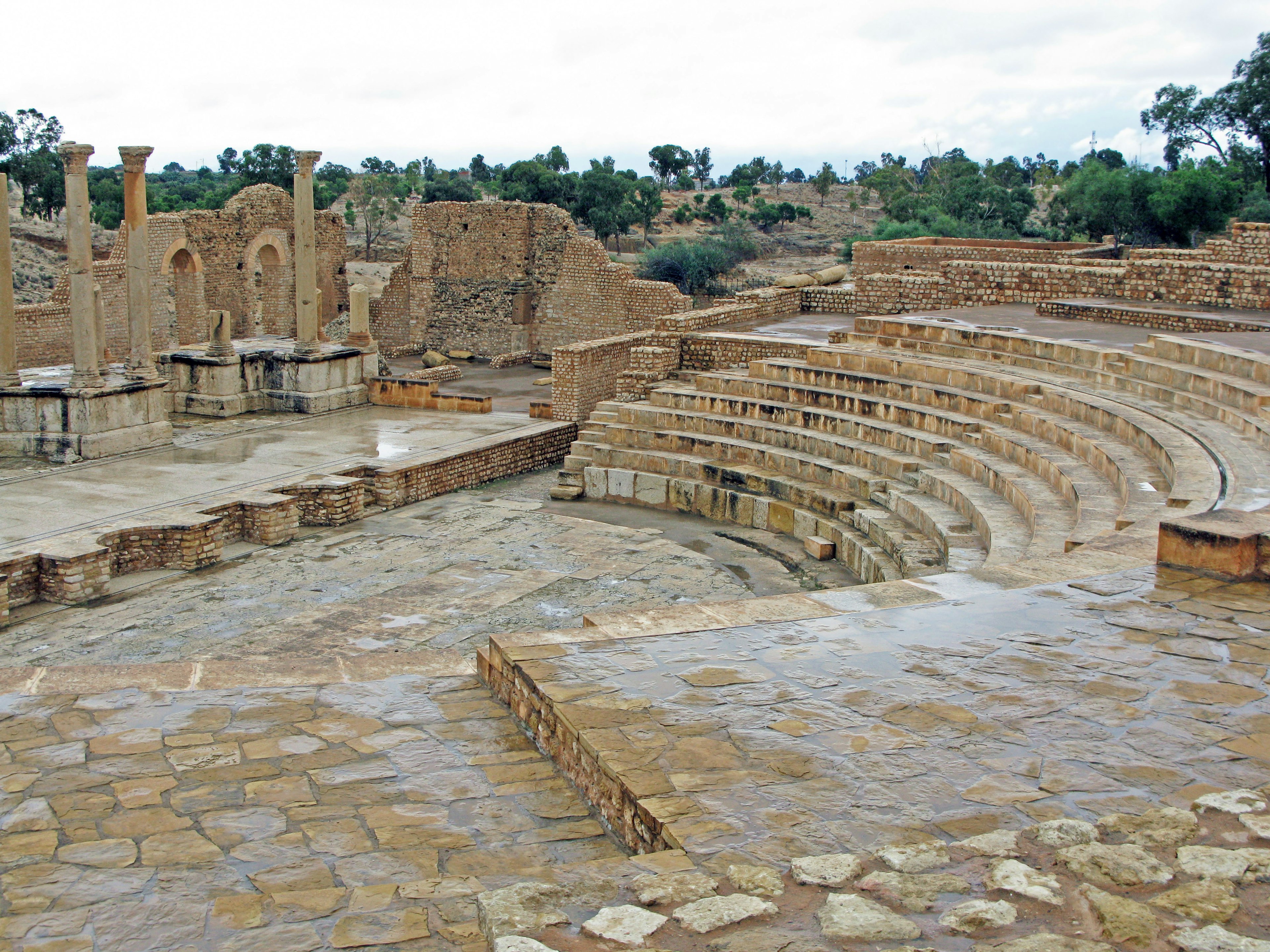 Rovine di un antico teatro con gradini di pietra e muri