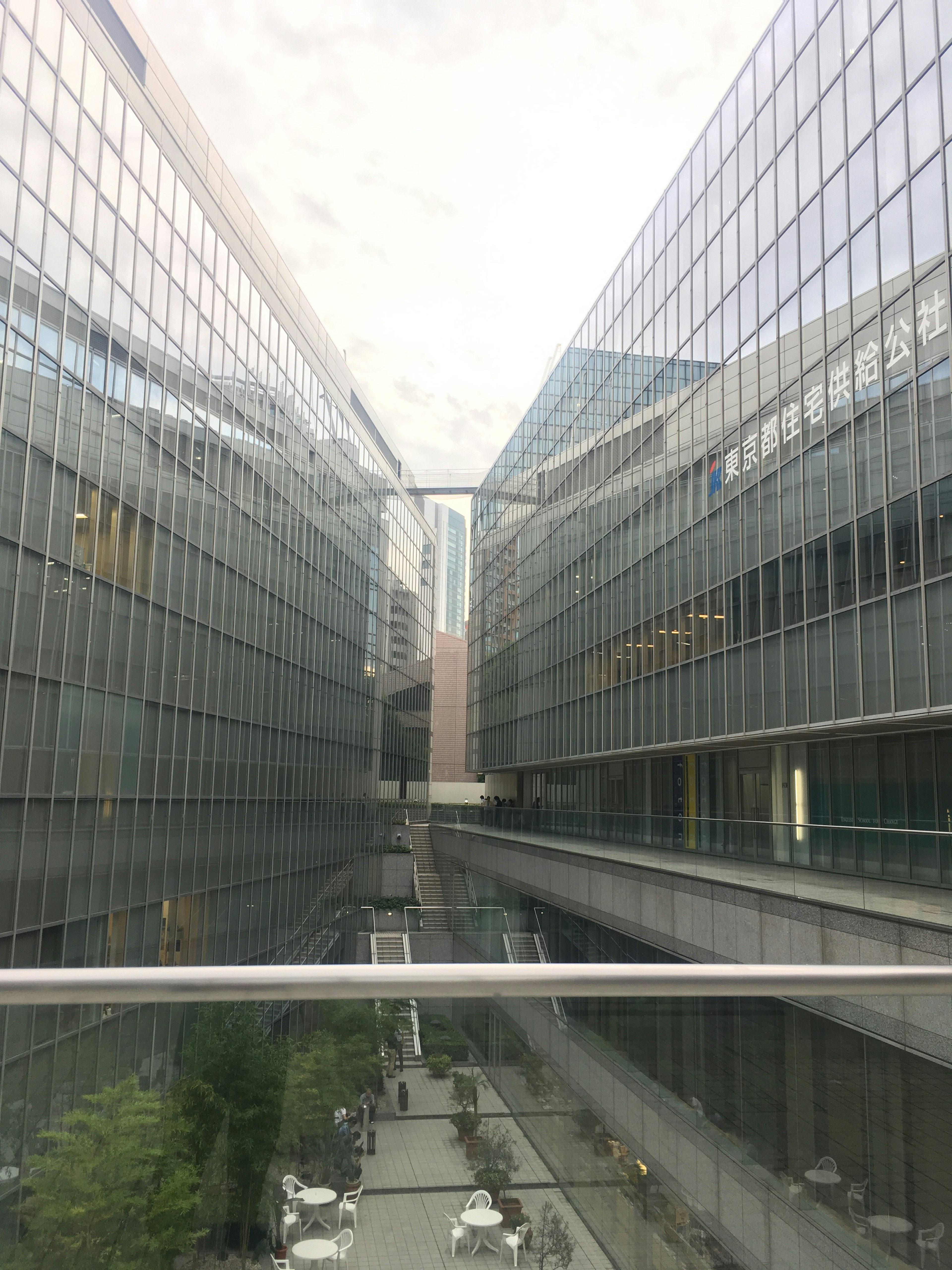 Cityscape featuring glass buildings with a walkway between them