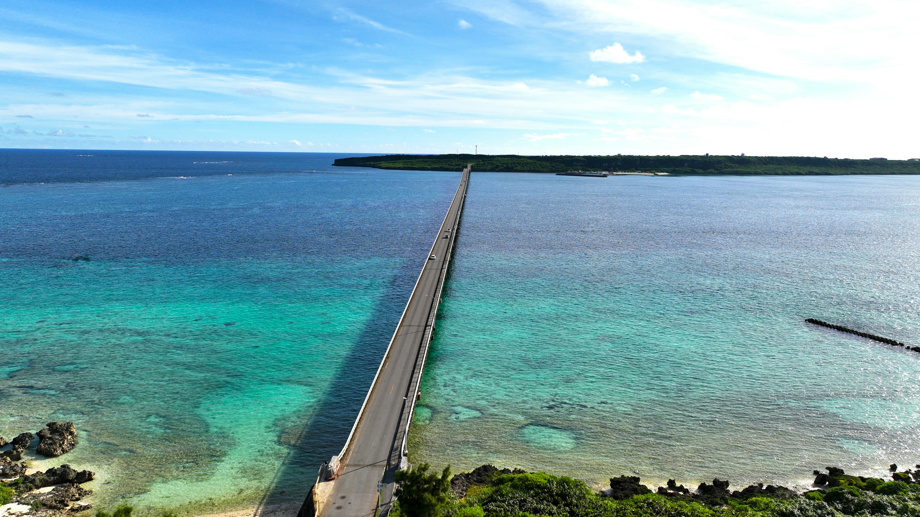 青い海と空の下に延びる長い橋の風景