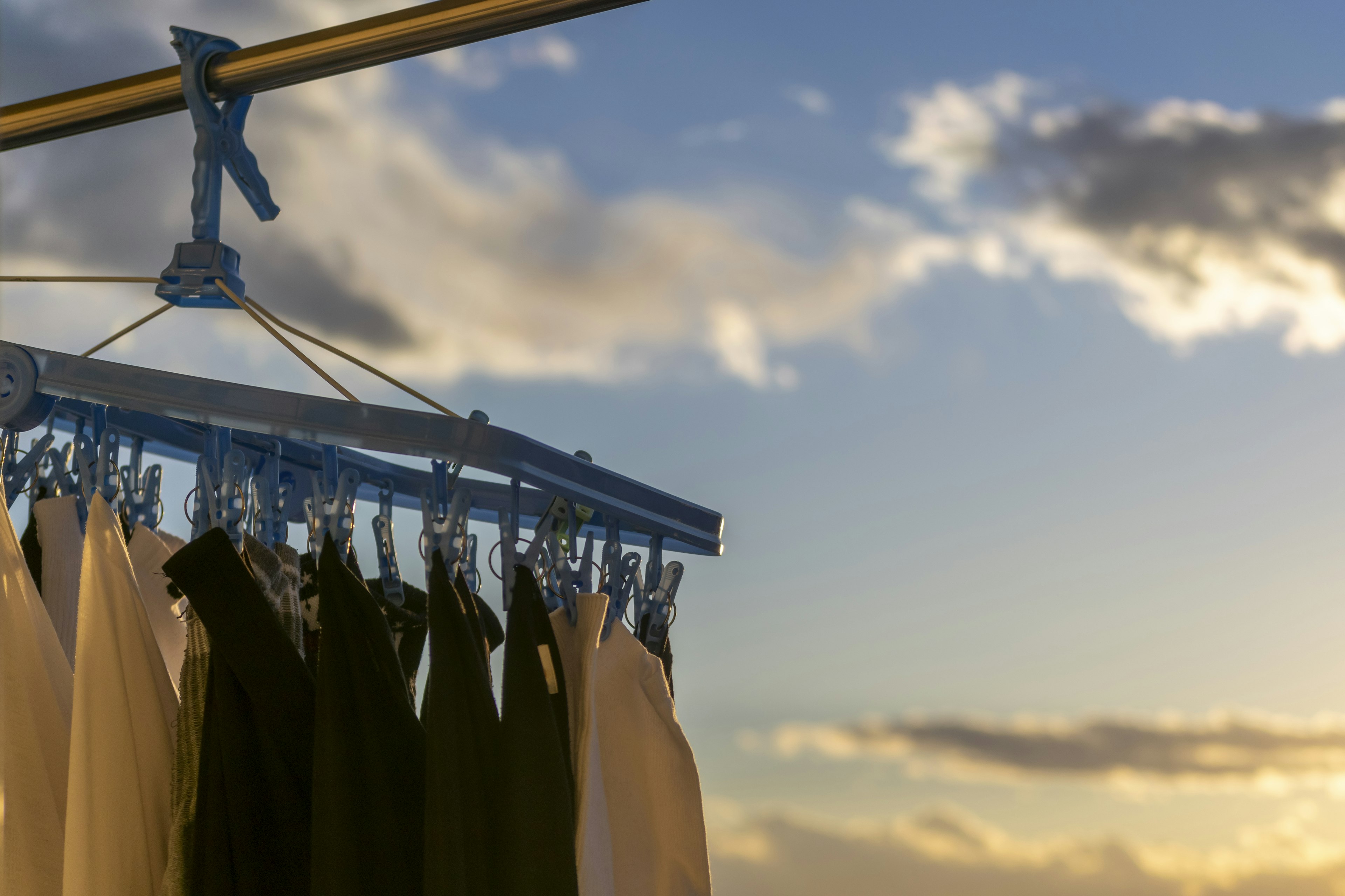 White and black clothes hanging under a blue sky