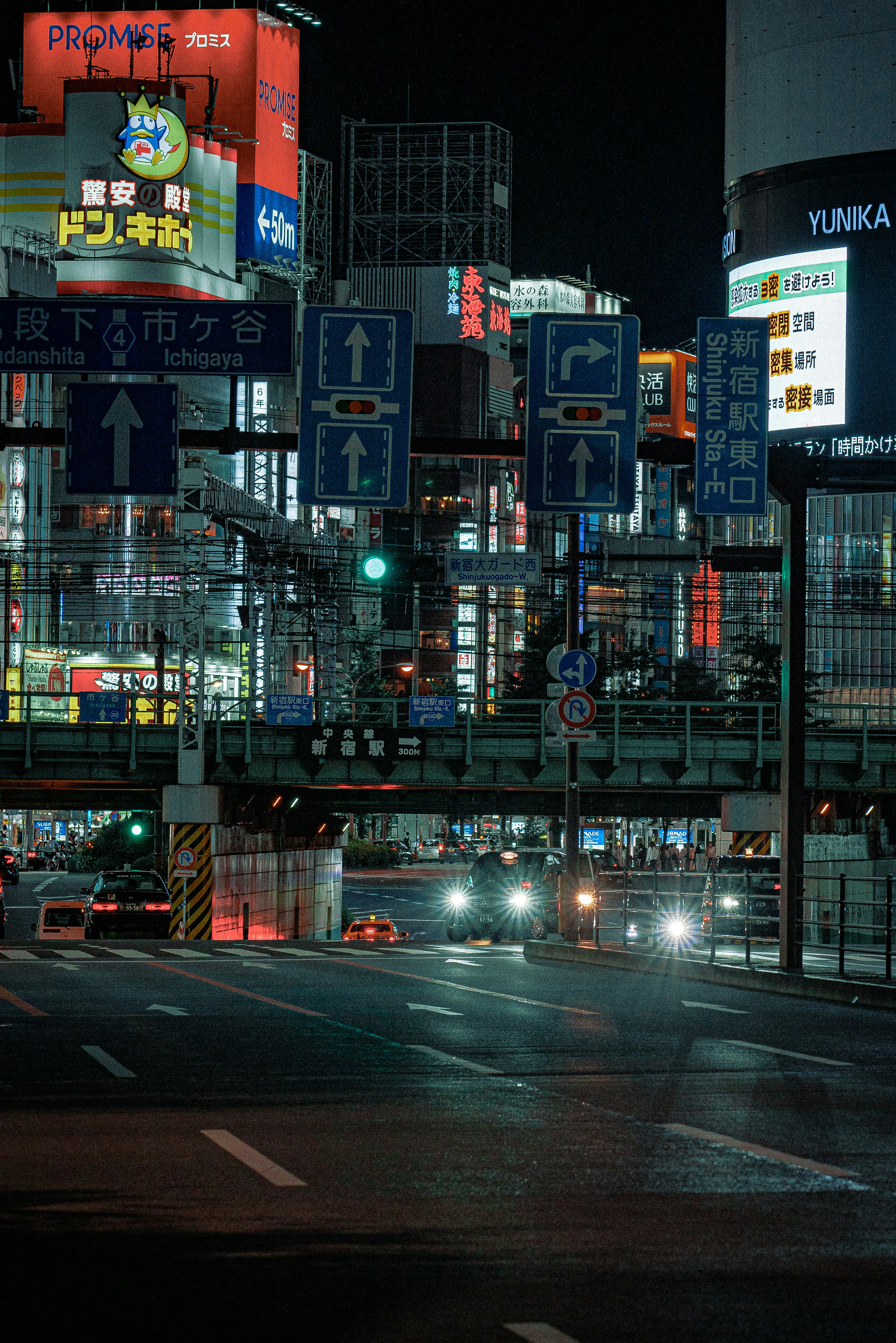 夜の都市風景で明るいネオン看板と交通信号が見える