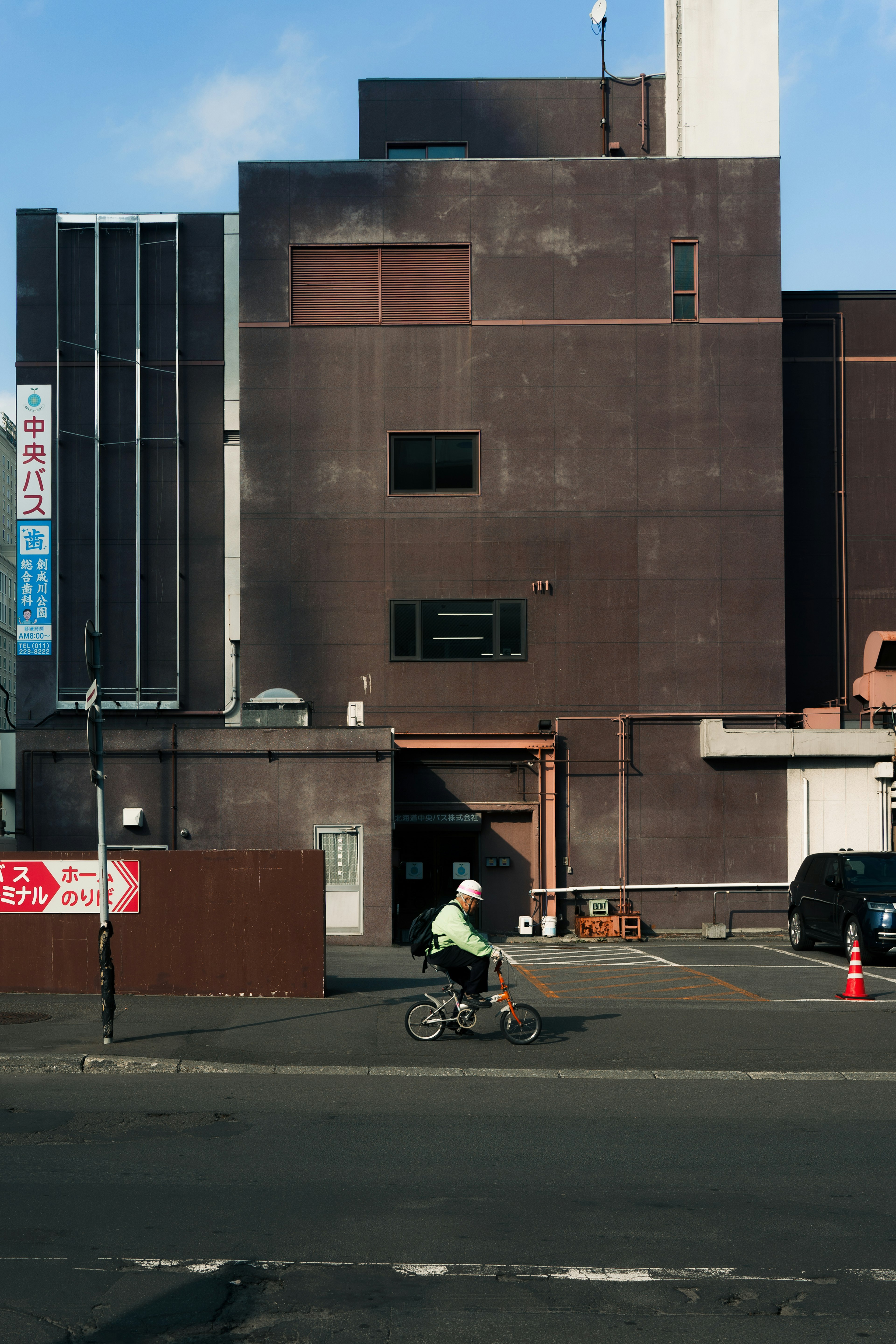 Scène urbaine avec une personne à vélo devant un bâtiment moderne