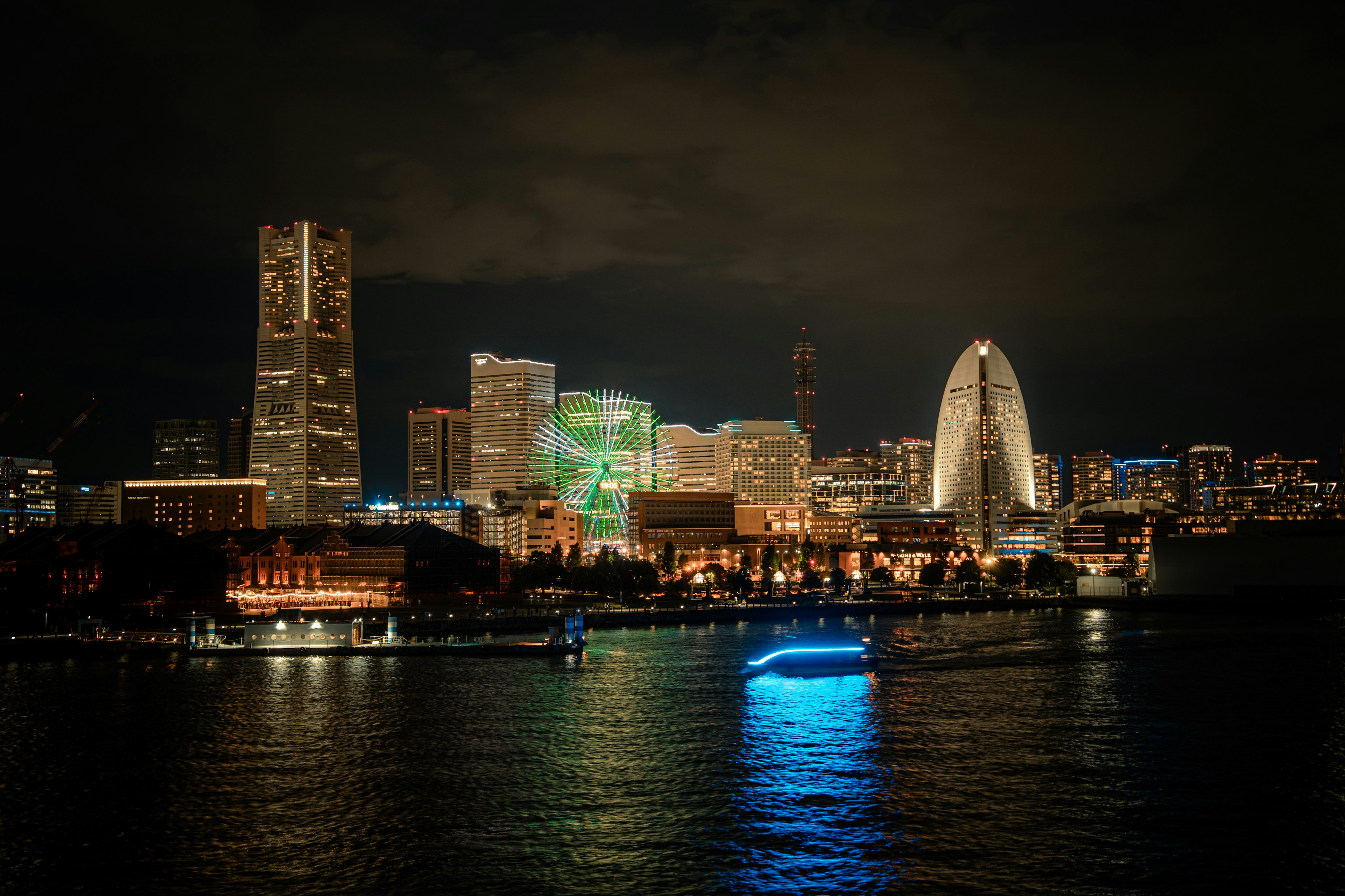 Nachtansicht von Yokohama mit beleuchteten Wolkenkratzern und einer ruhigen Uferpromenade