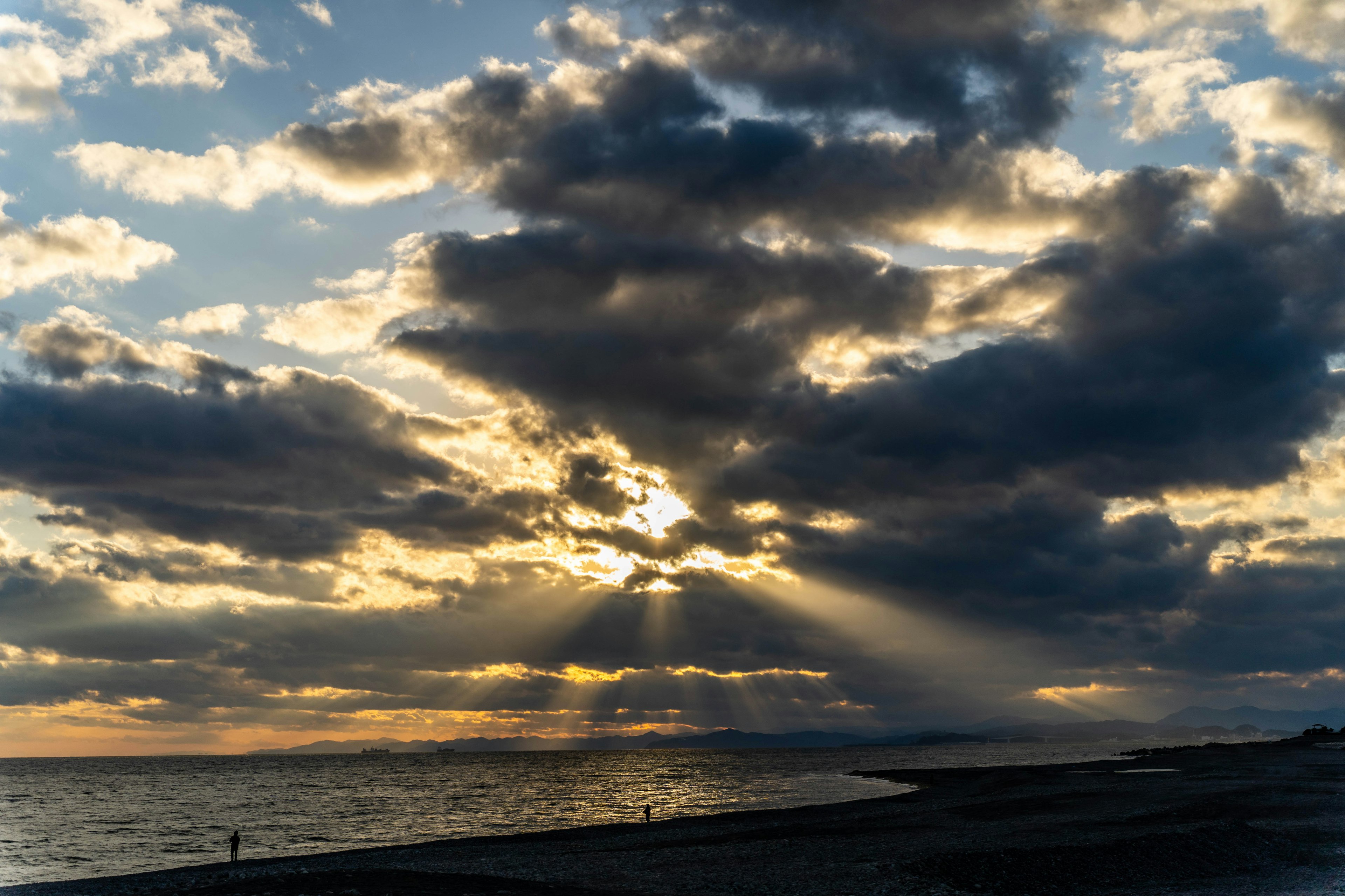 Beach scene with sunlight breaking through clouds