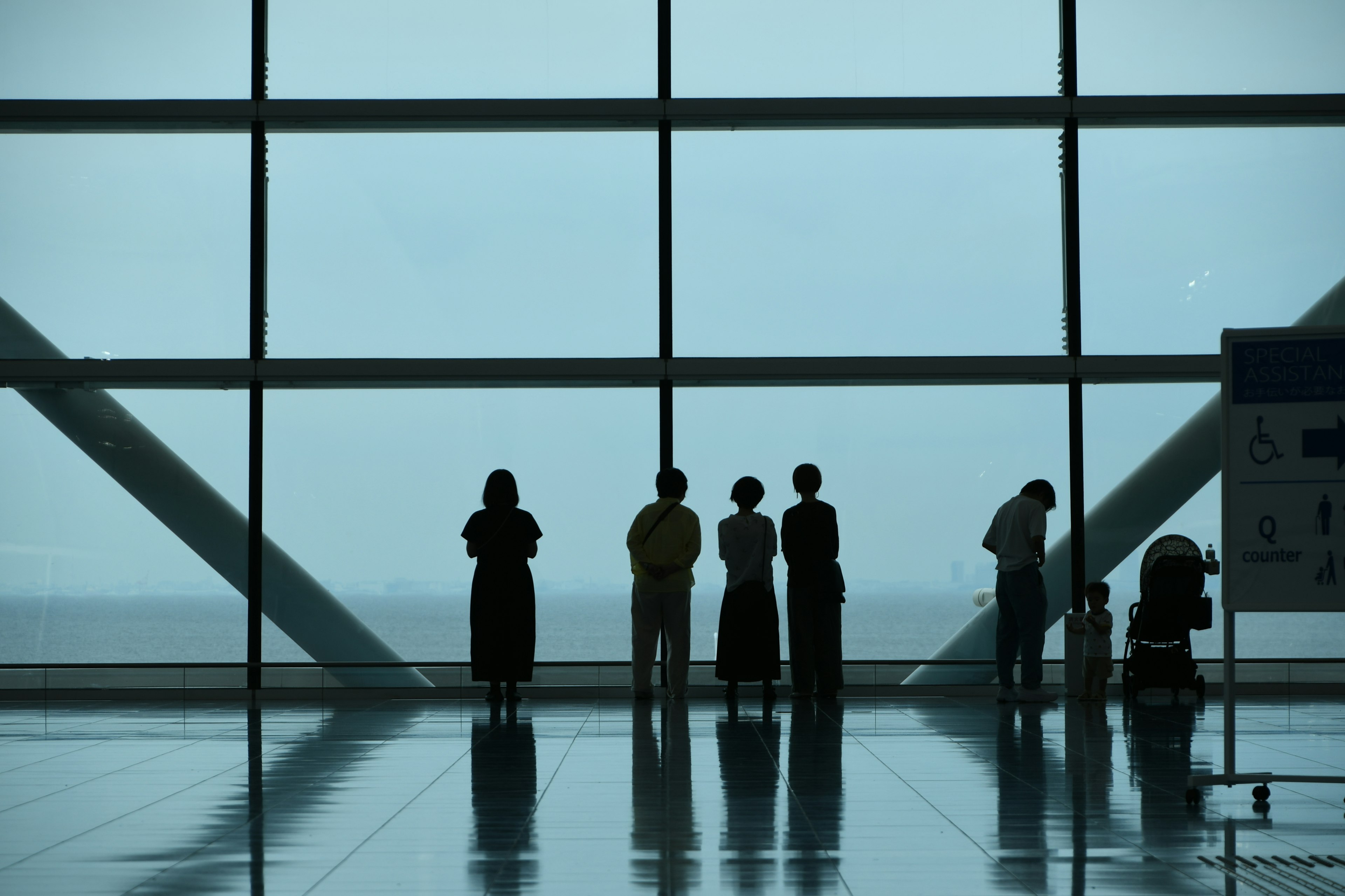 Siluetas de personas frente a grandes ventanas del aeropuerto