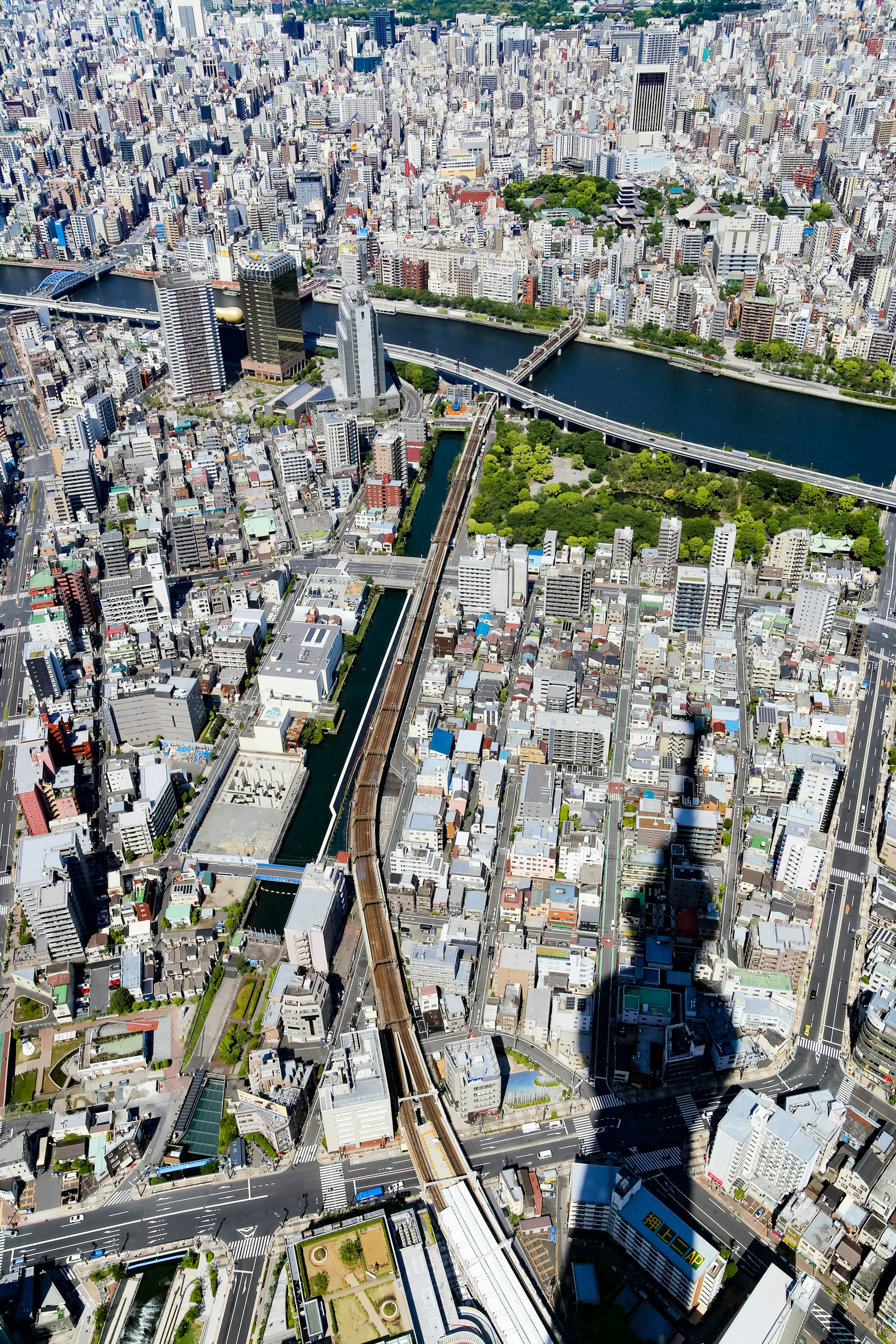 Luftaufnahme von Tokio mit dem Schatten des Tokyo Skytree Sichtbar Nahegelegener Fluss und Grünflächen