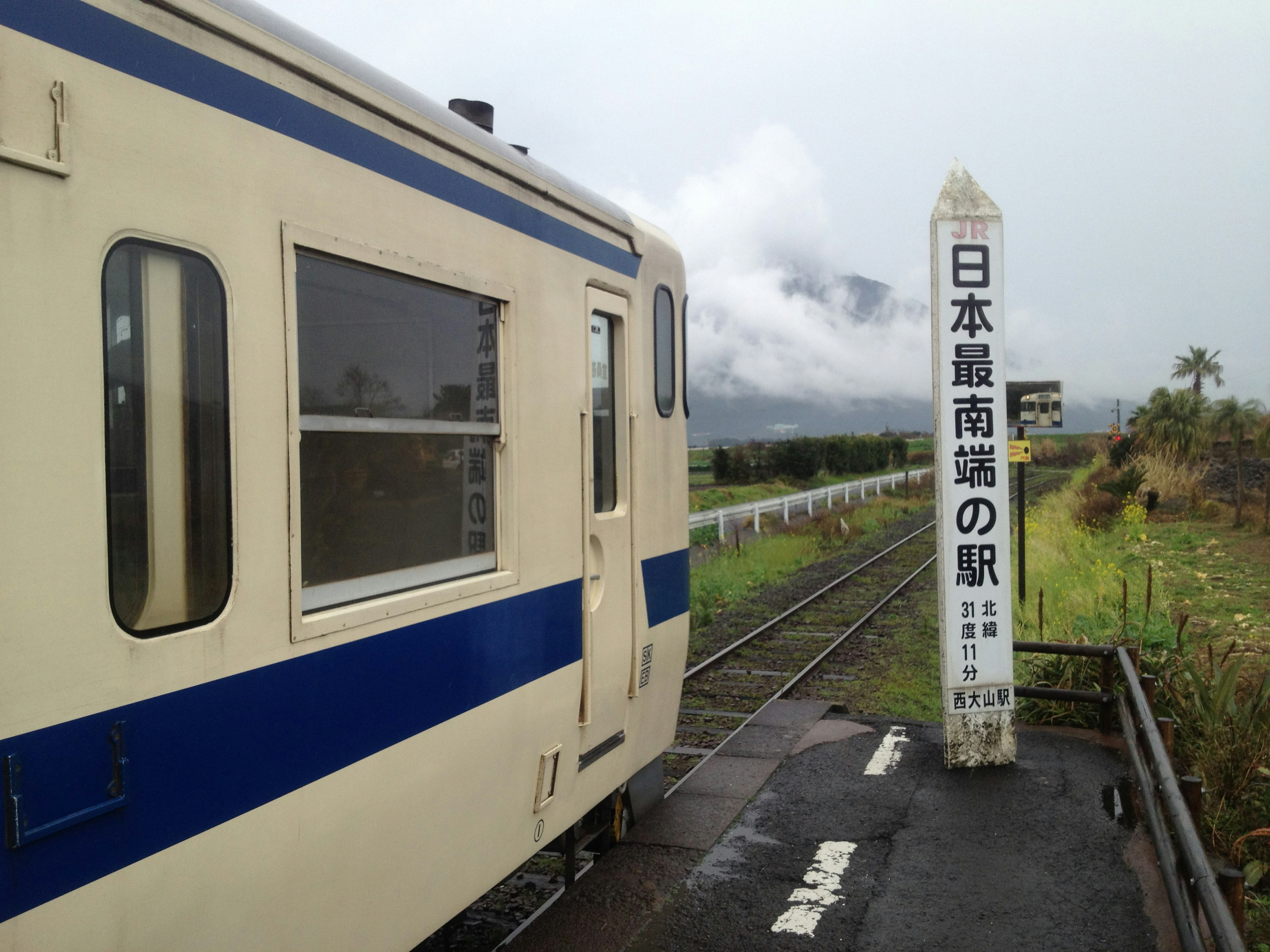 日本の駅の看板と列車の側面が映る風景