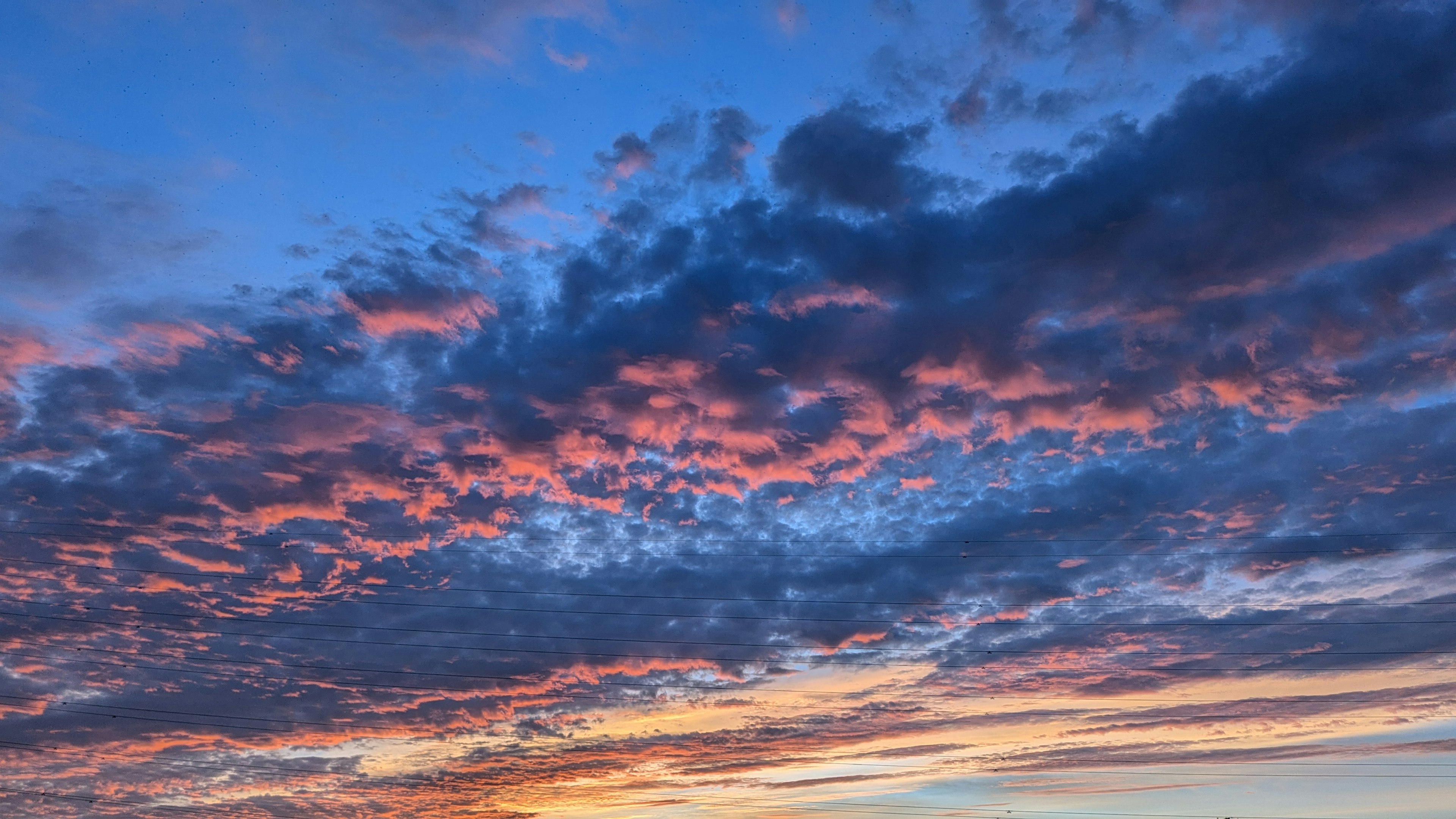 青い空にオレンジとピンクの雲が広がる美しい夕焼け