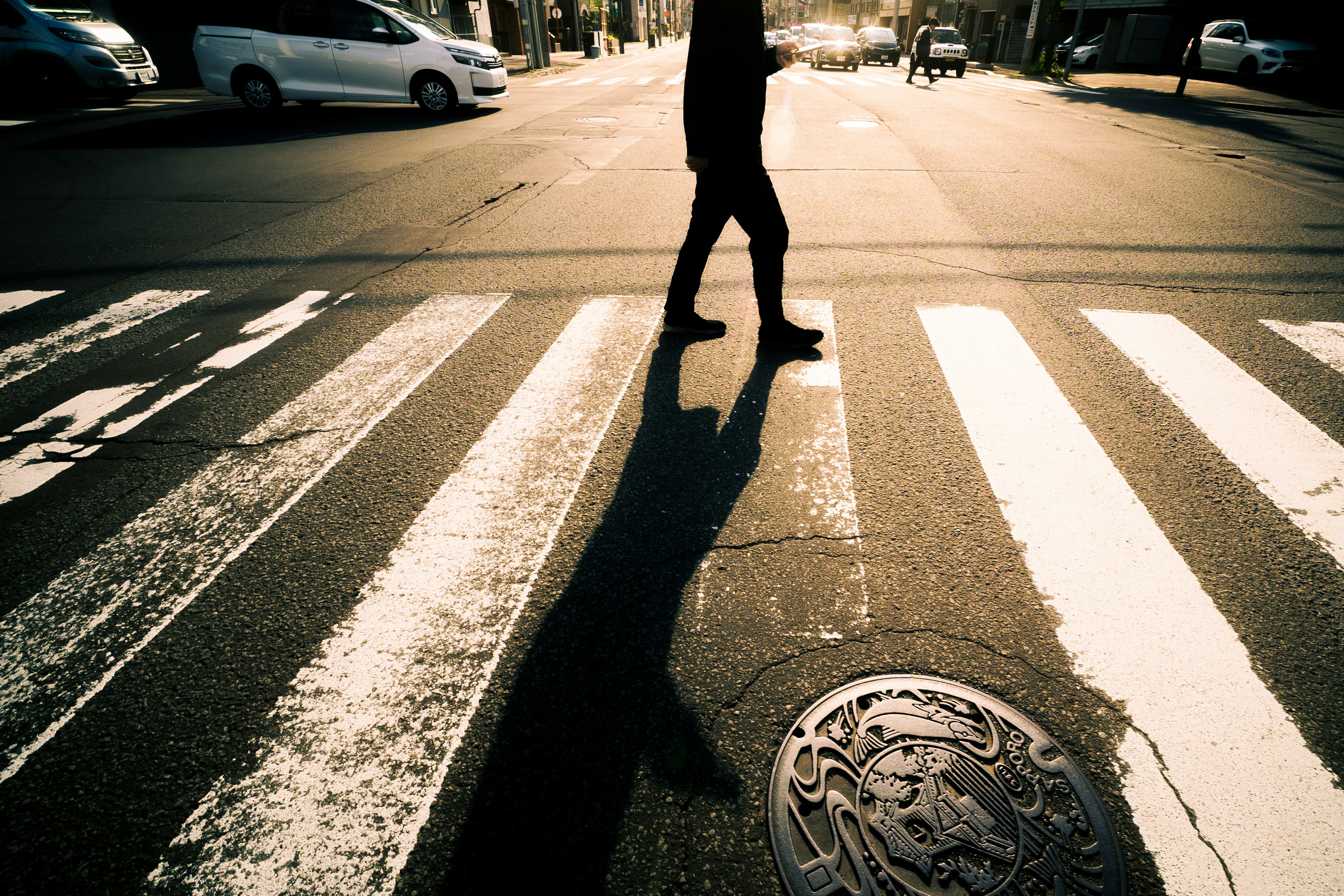 Silhouette of a pedestrian crossing a zebra crossing