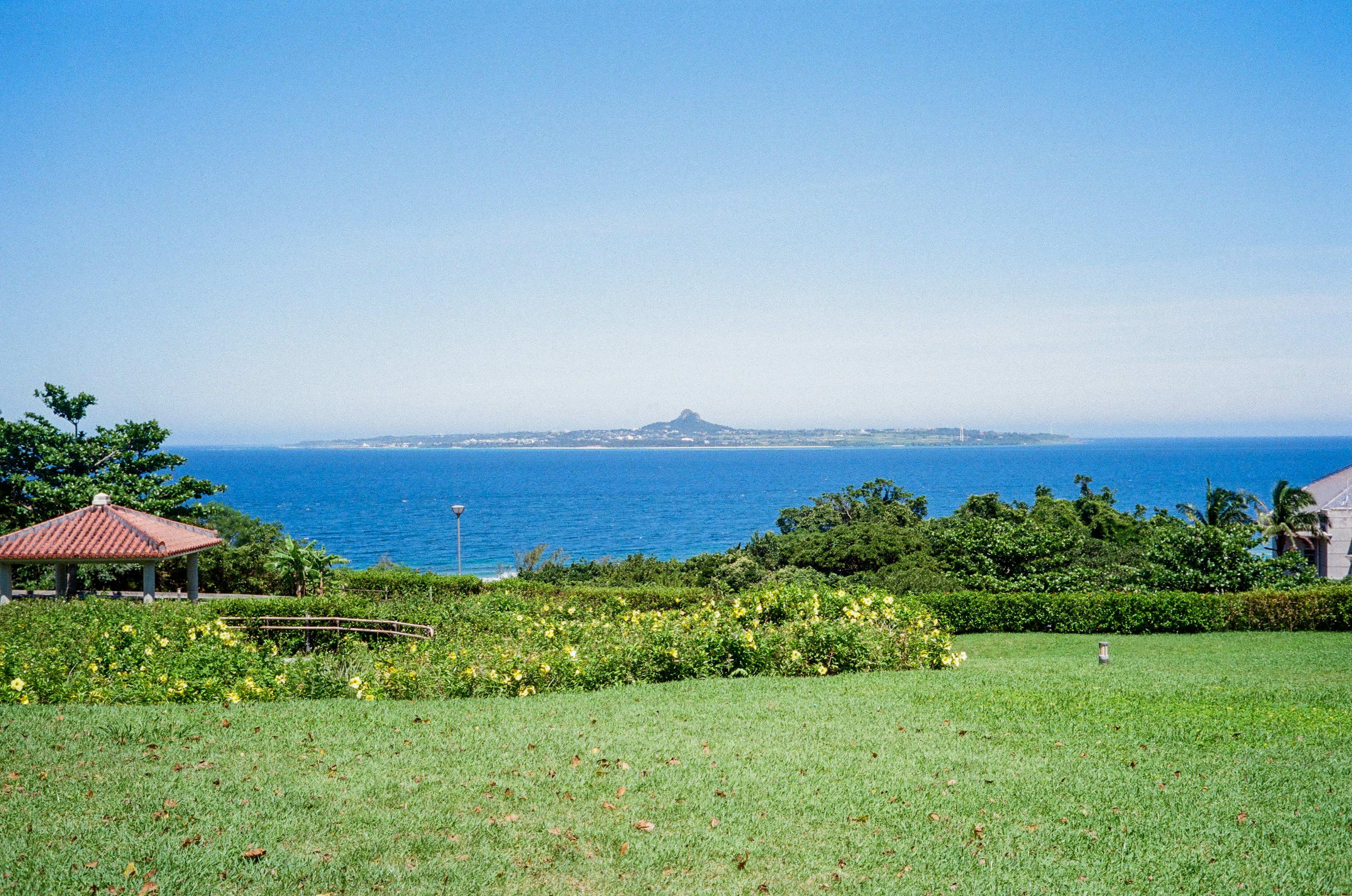 蓝色海洋与绿色草坪和凉亭的风景