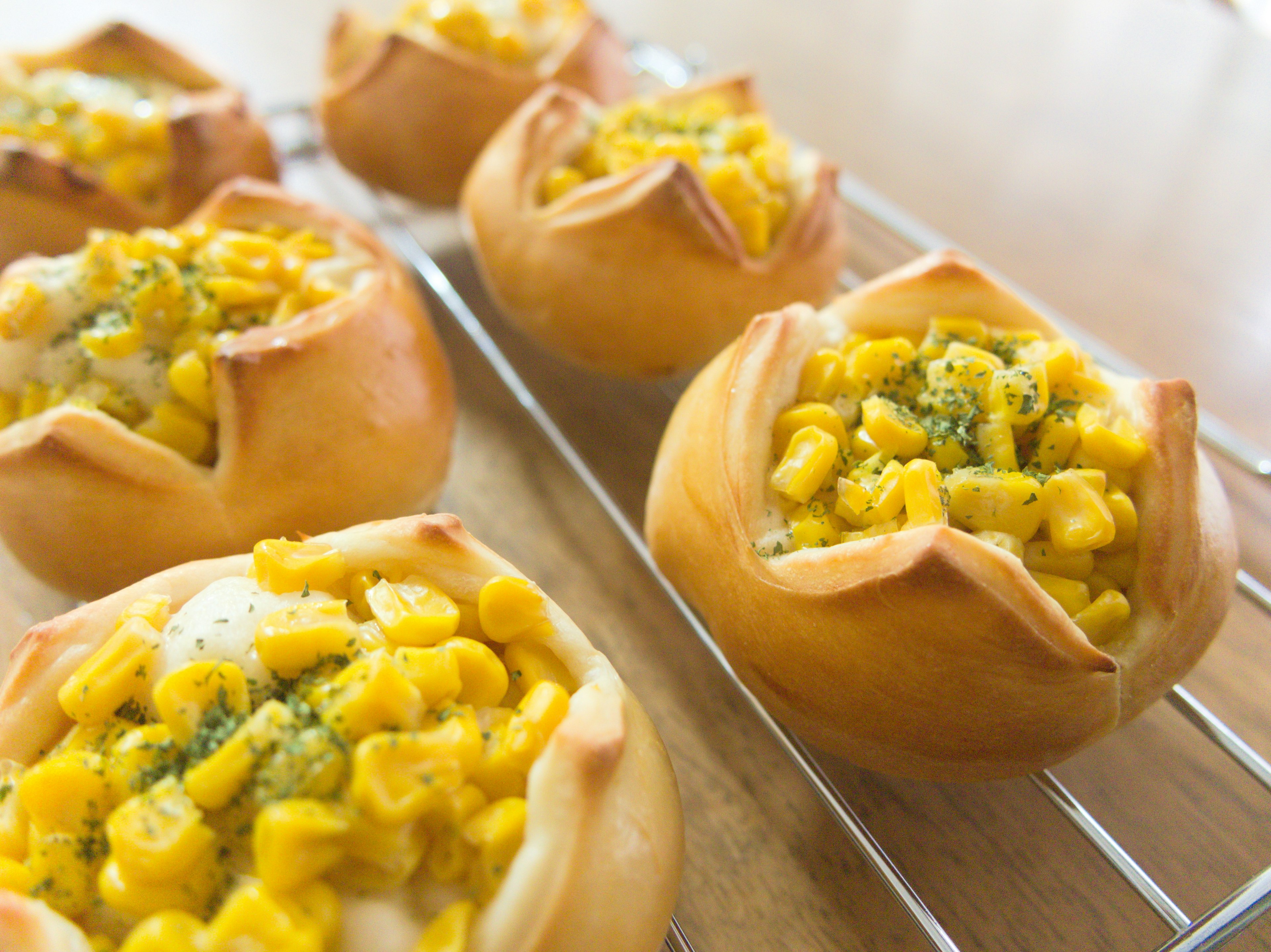 Freshly baked corn pastries arranged on a cooling rack