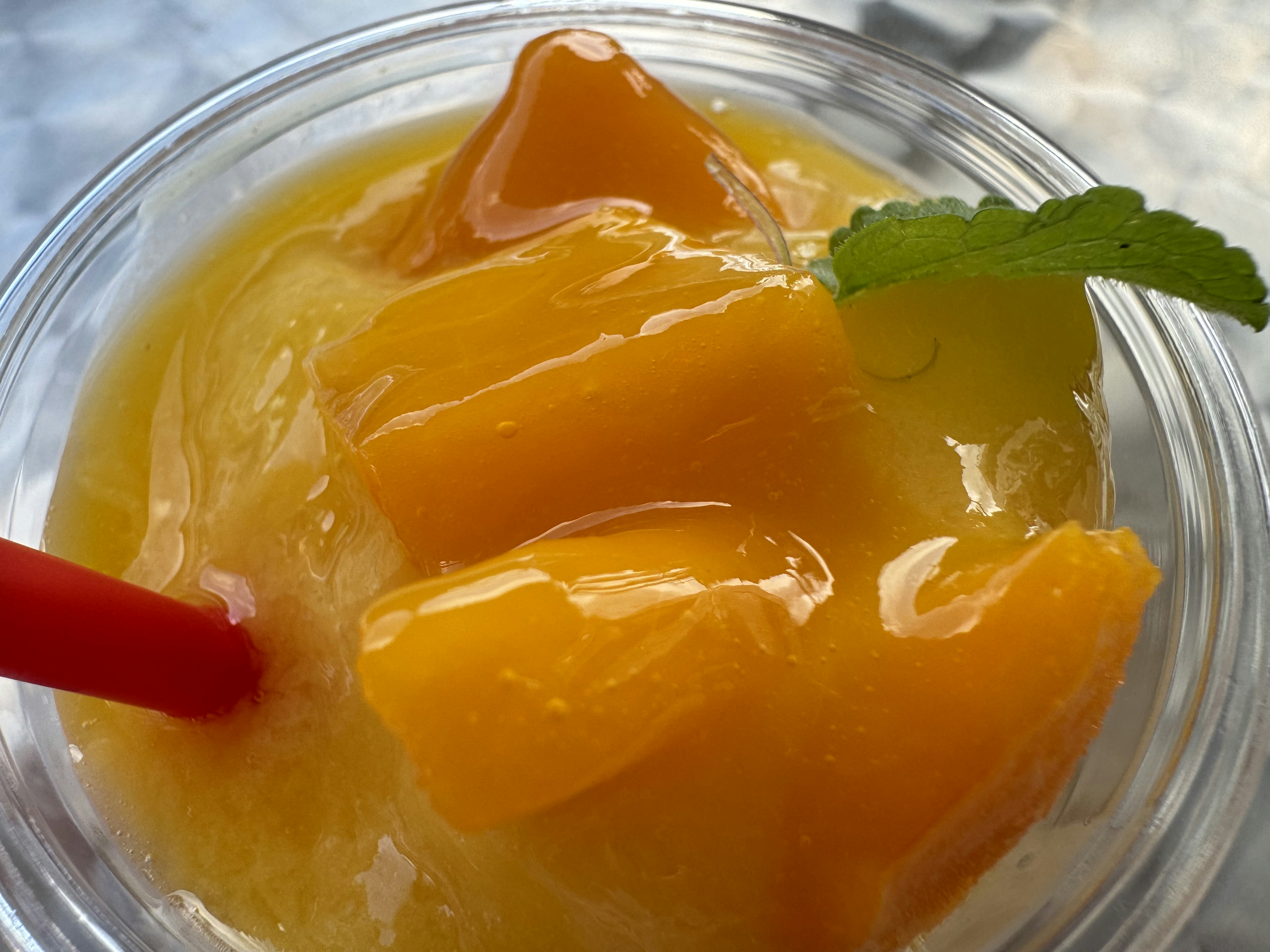 Frullato di mango guarnito con foglie di menta