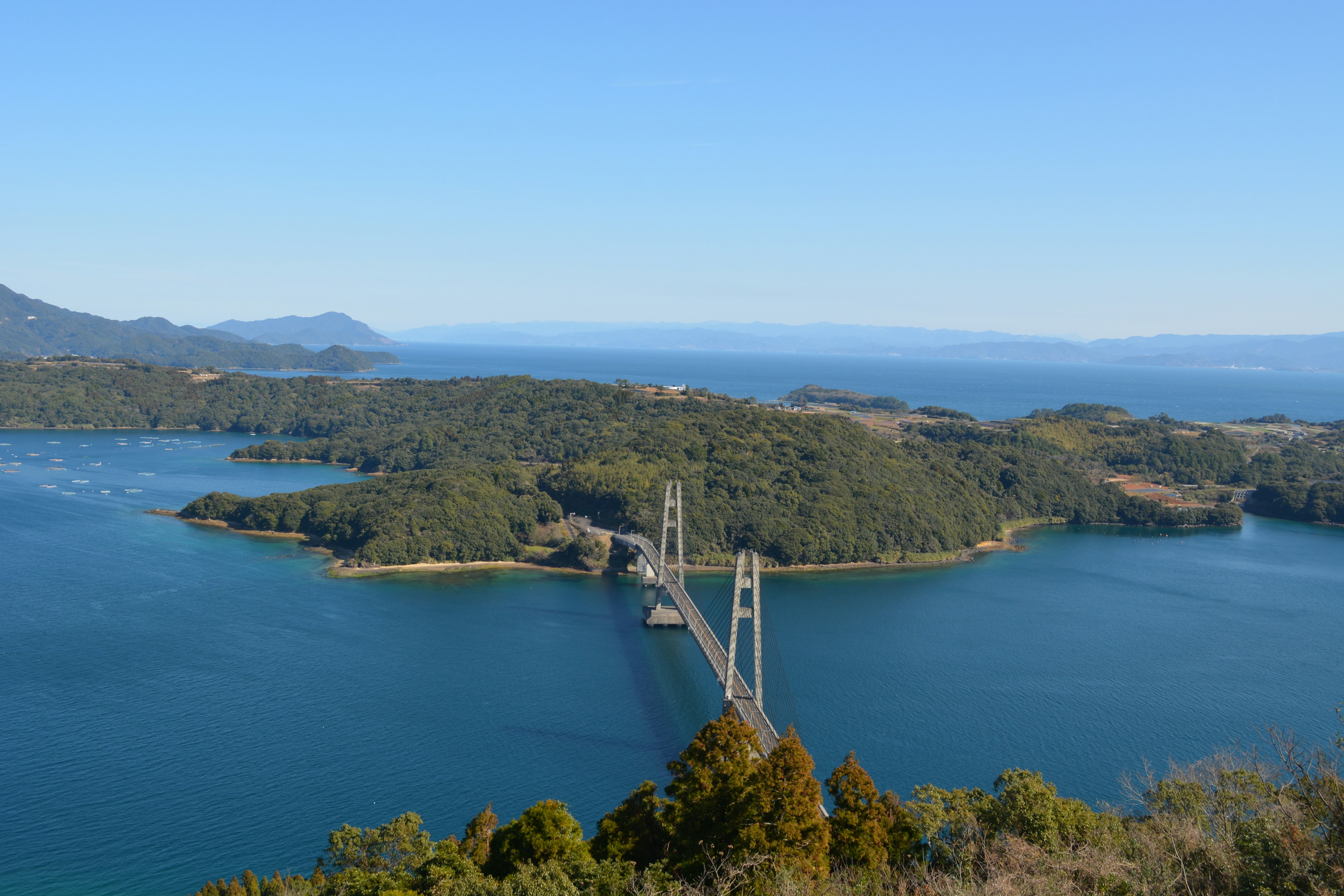 Vista panoramica di un ponte su acqua blu circondato da isole verdi