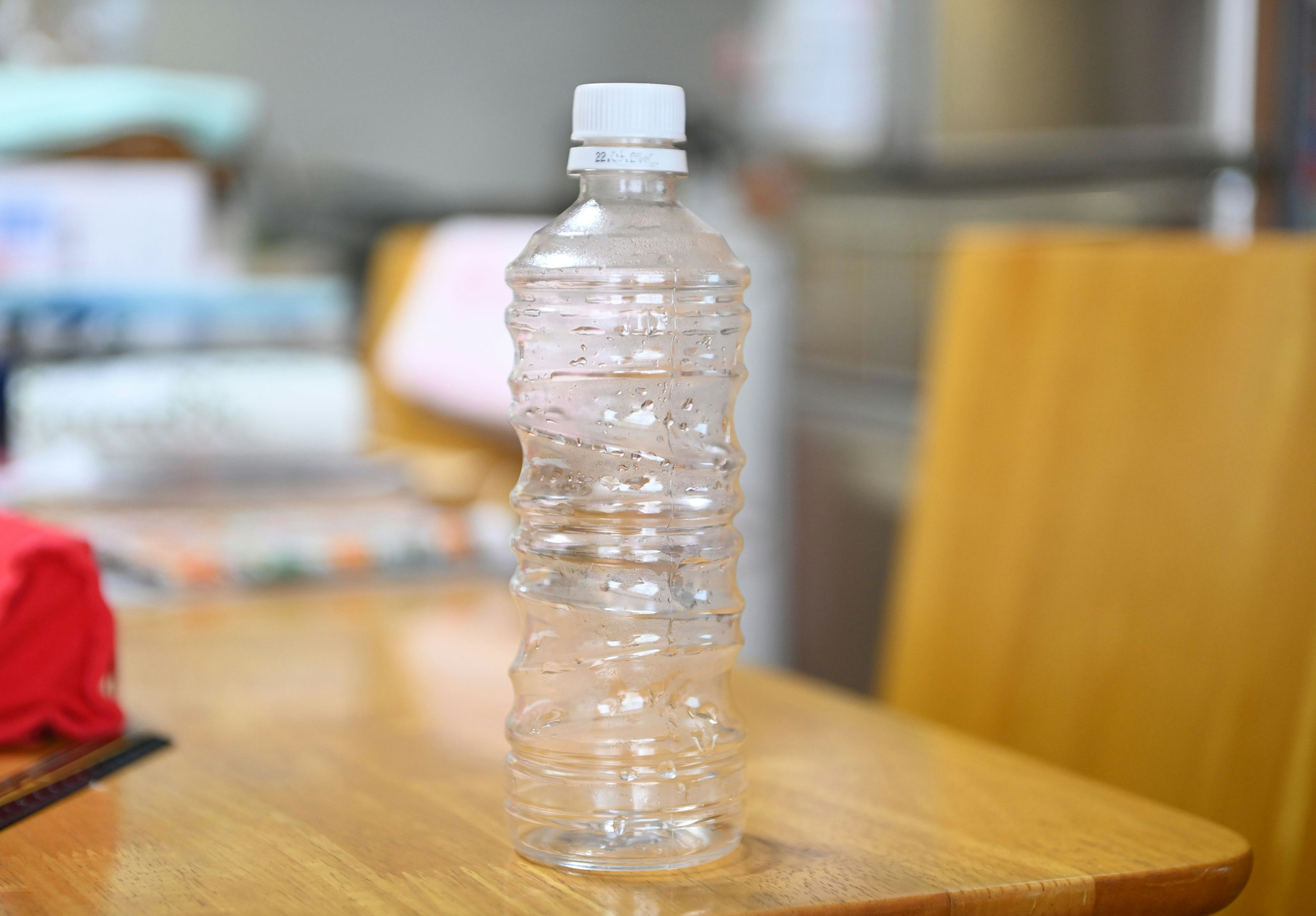 Clear plastic water bottle standing on a wooden table