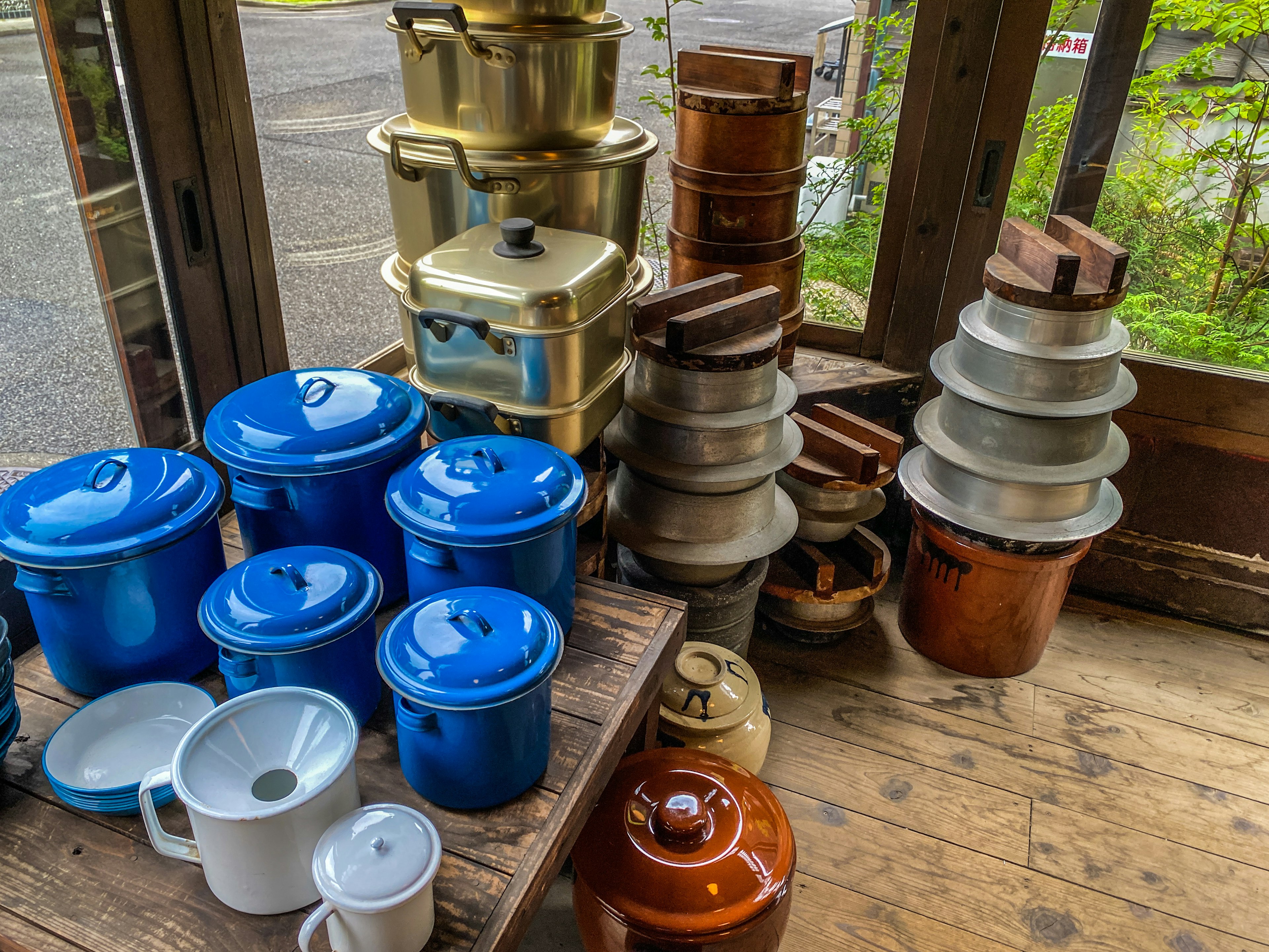 A collection of blue pots and various cooking utensils stacked together