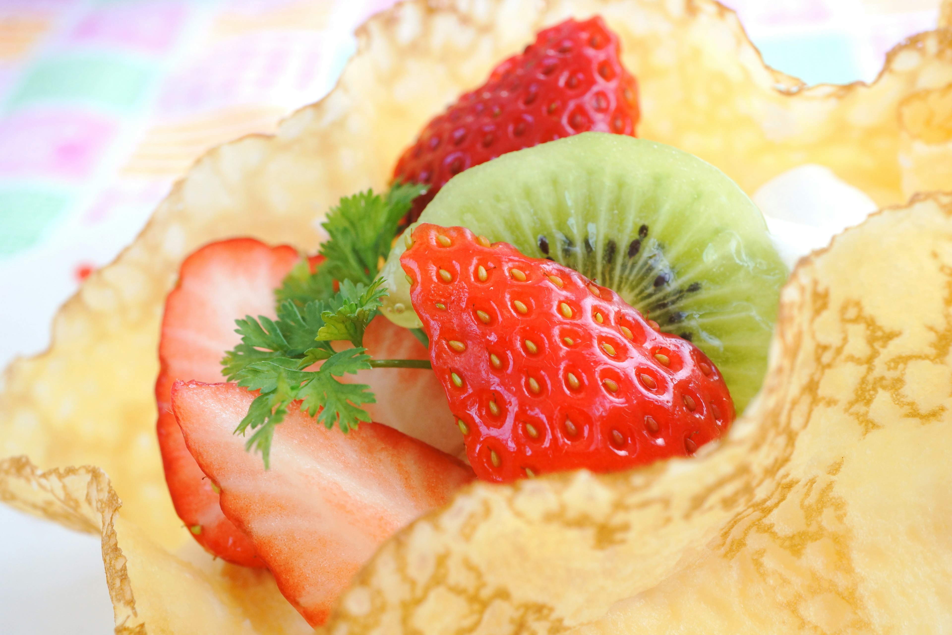 Dessert in einer Schokoladenschale gefüllt mit verschiedenen Früchten wie Erdbeeren und Kiwi