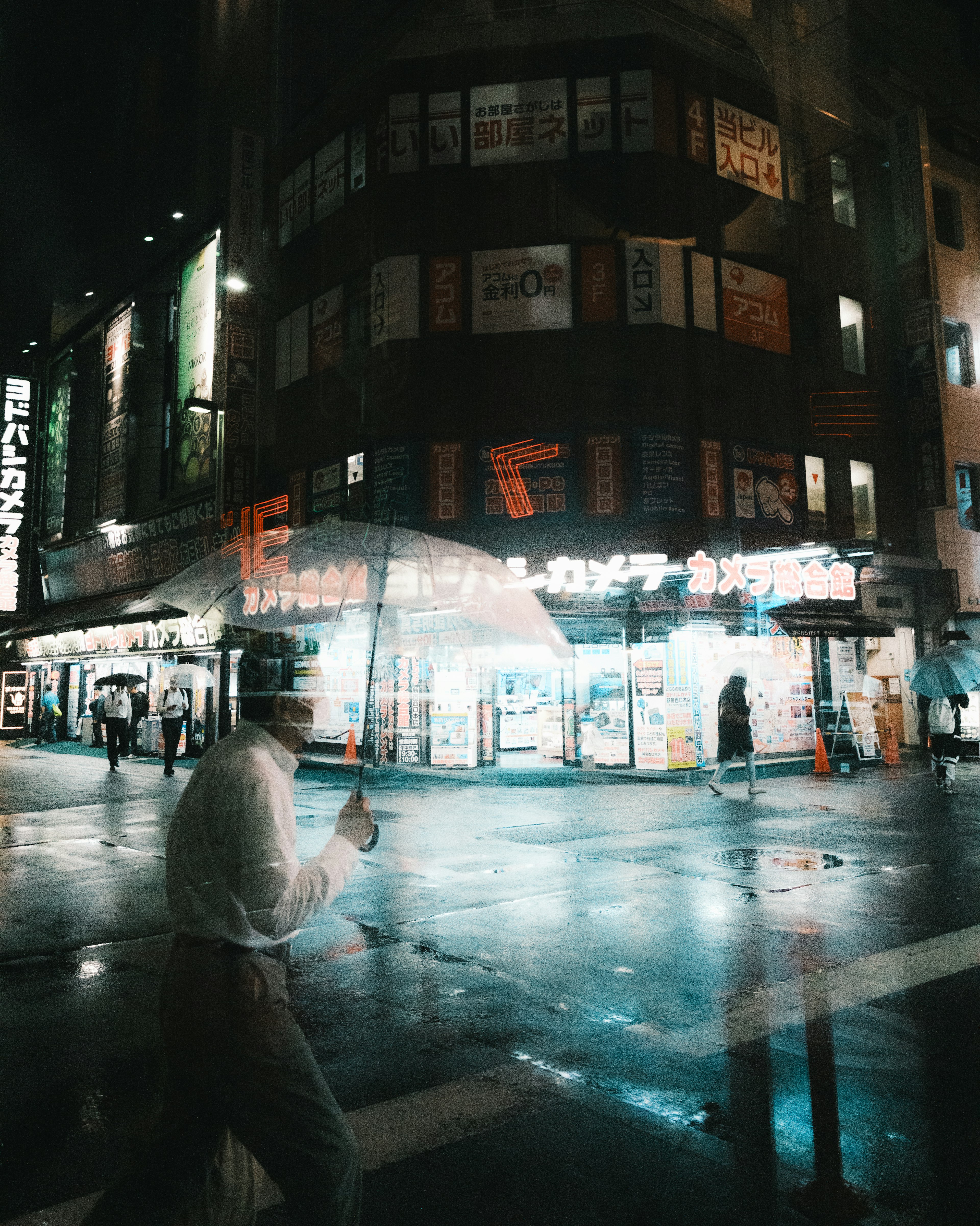 Städtische Szene bei Nacht mit einer Person, die einen Regenschirm hält