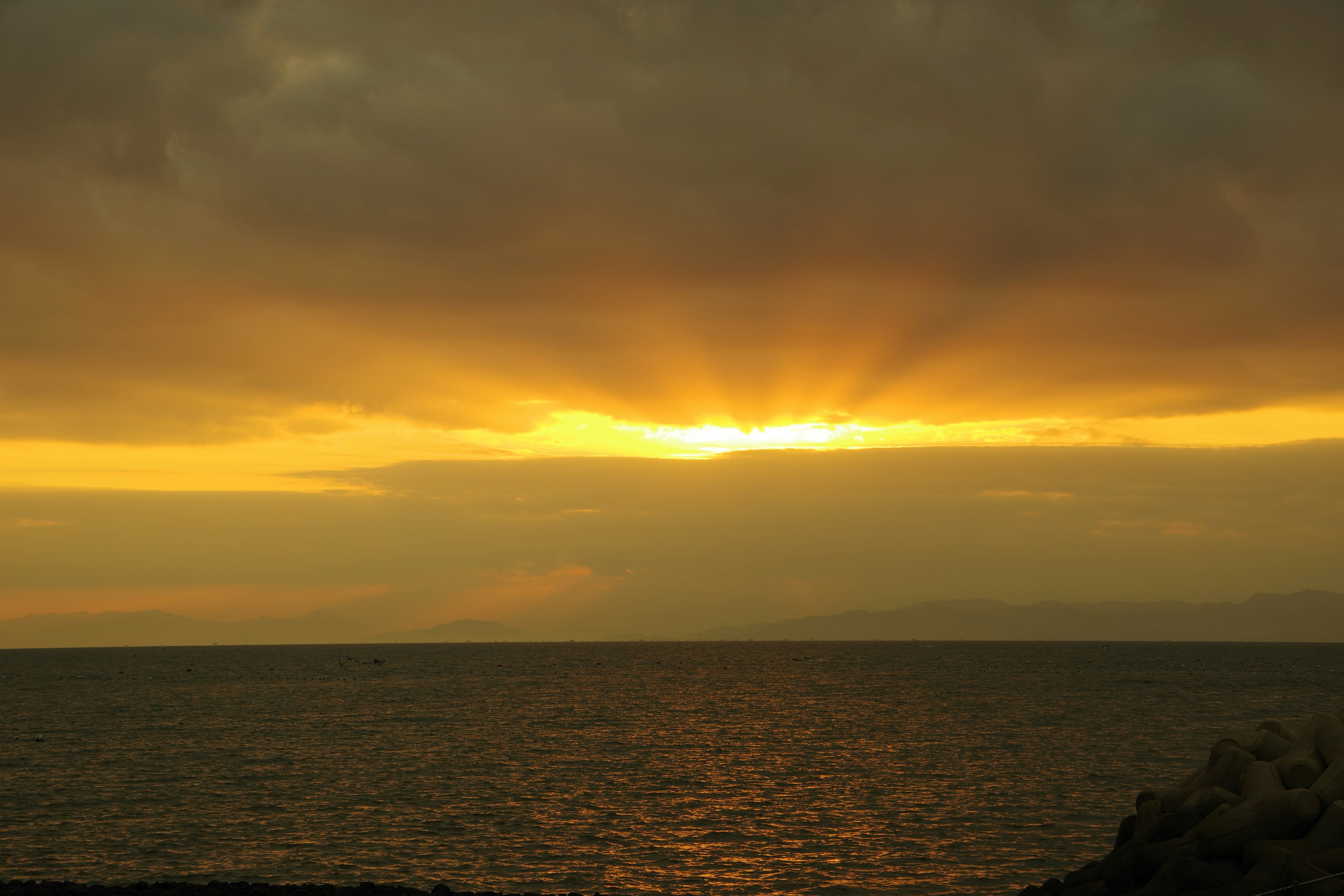 Atardecer sobre el océano con luz radiante y nubes dramáticas