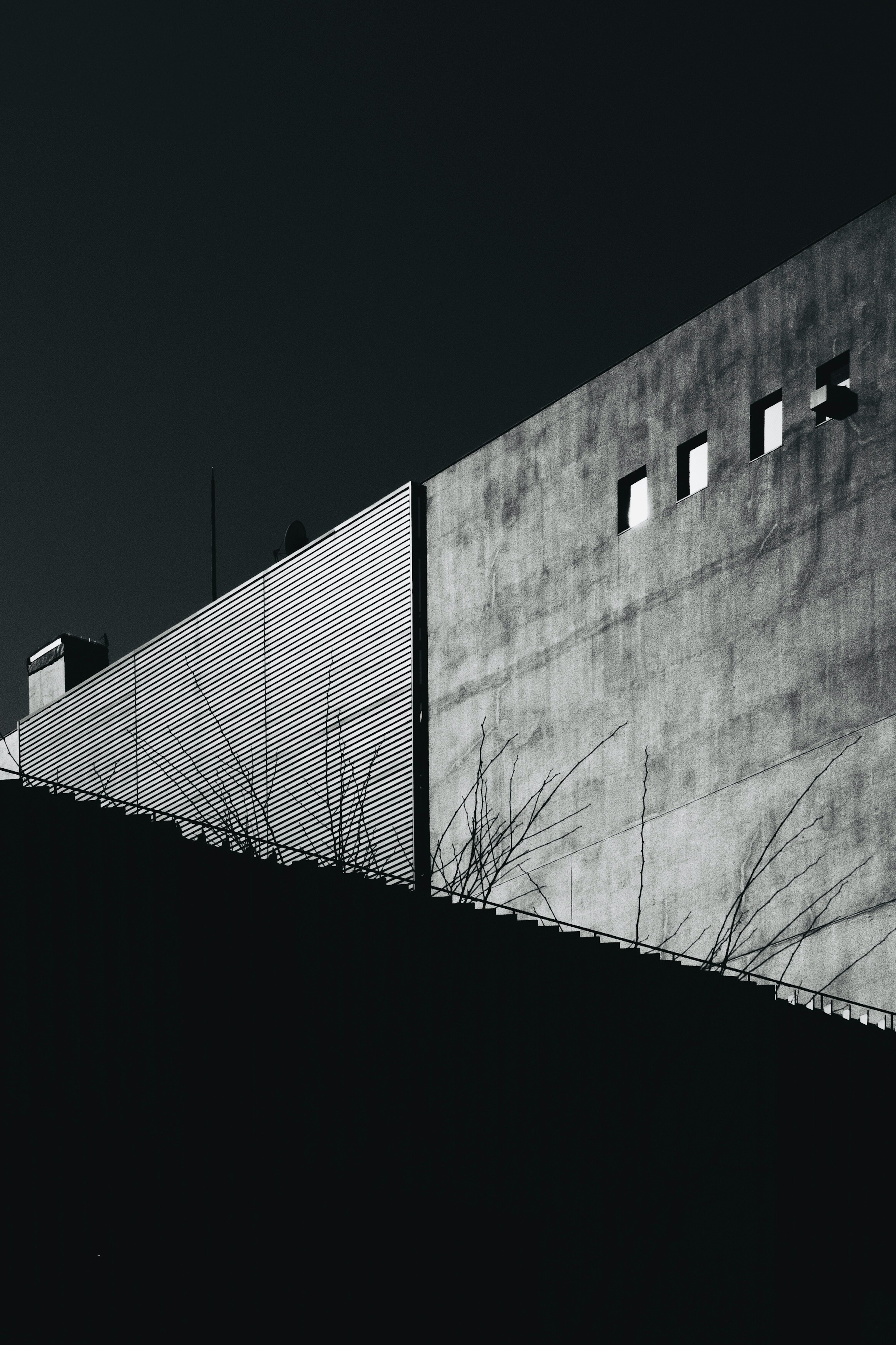 Imagen en blanco y negro que destaca el contraste entre el exterior de un edificio y las sombras