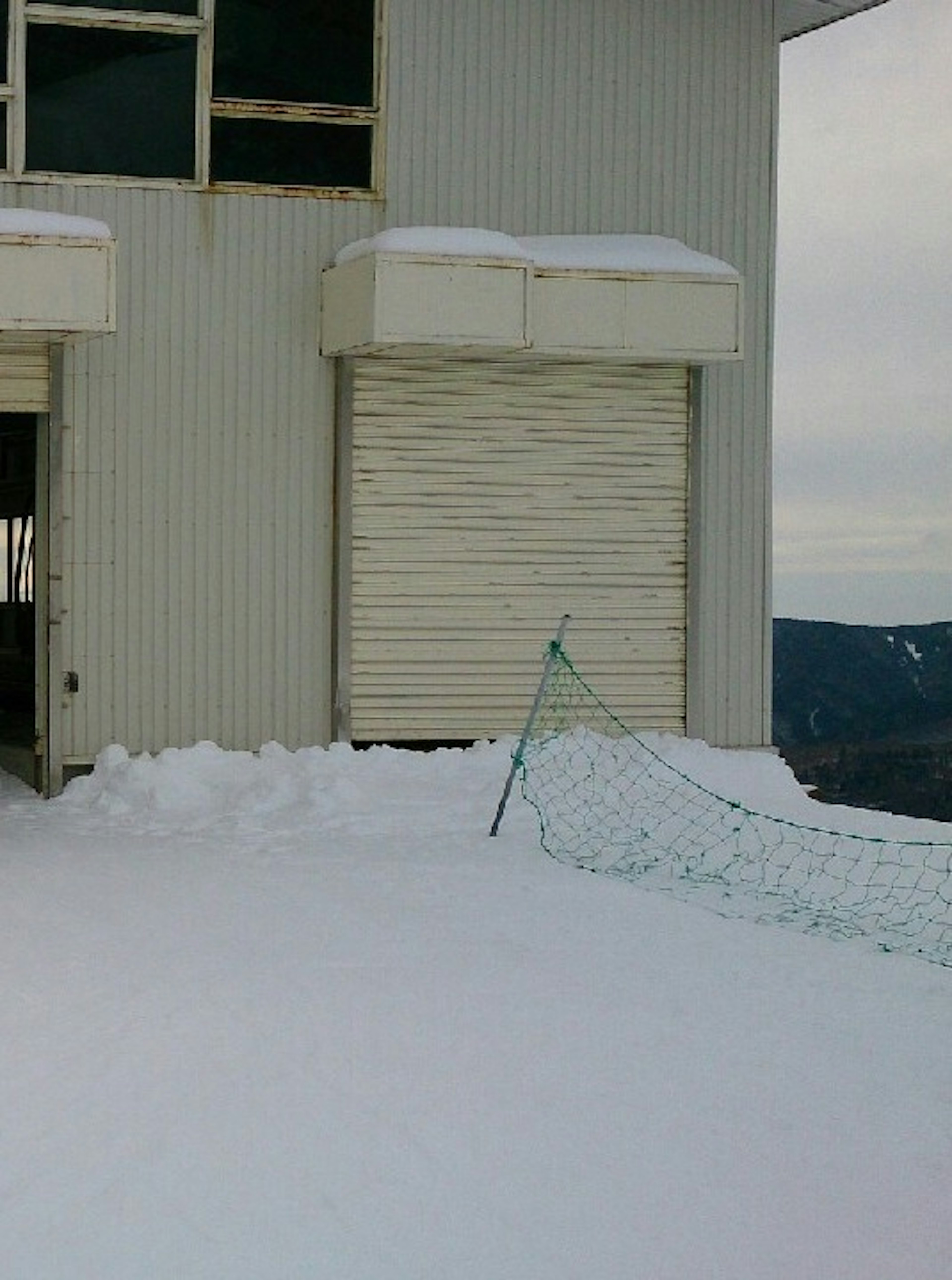 雪に覆われた建物の側面と閉じられたシャッター