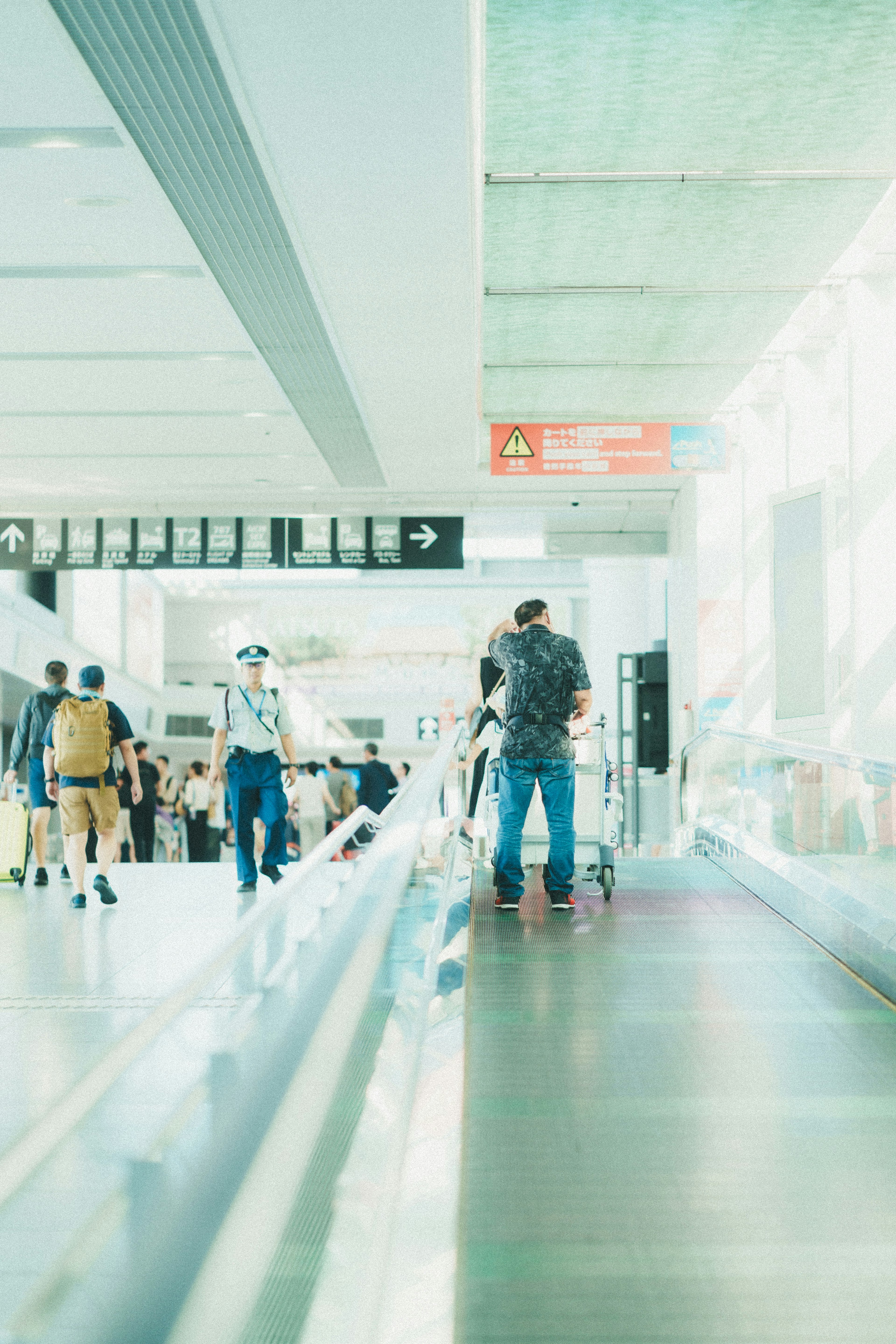 People moving inside an airport bright lighting and transparent design