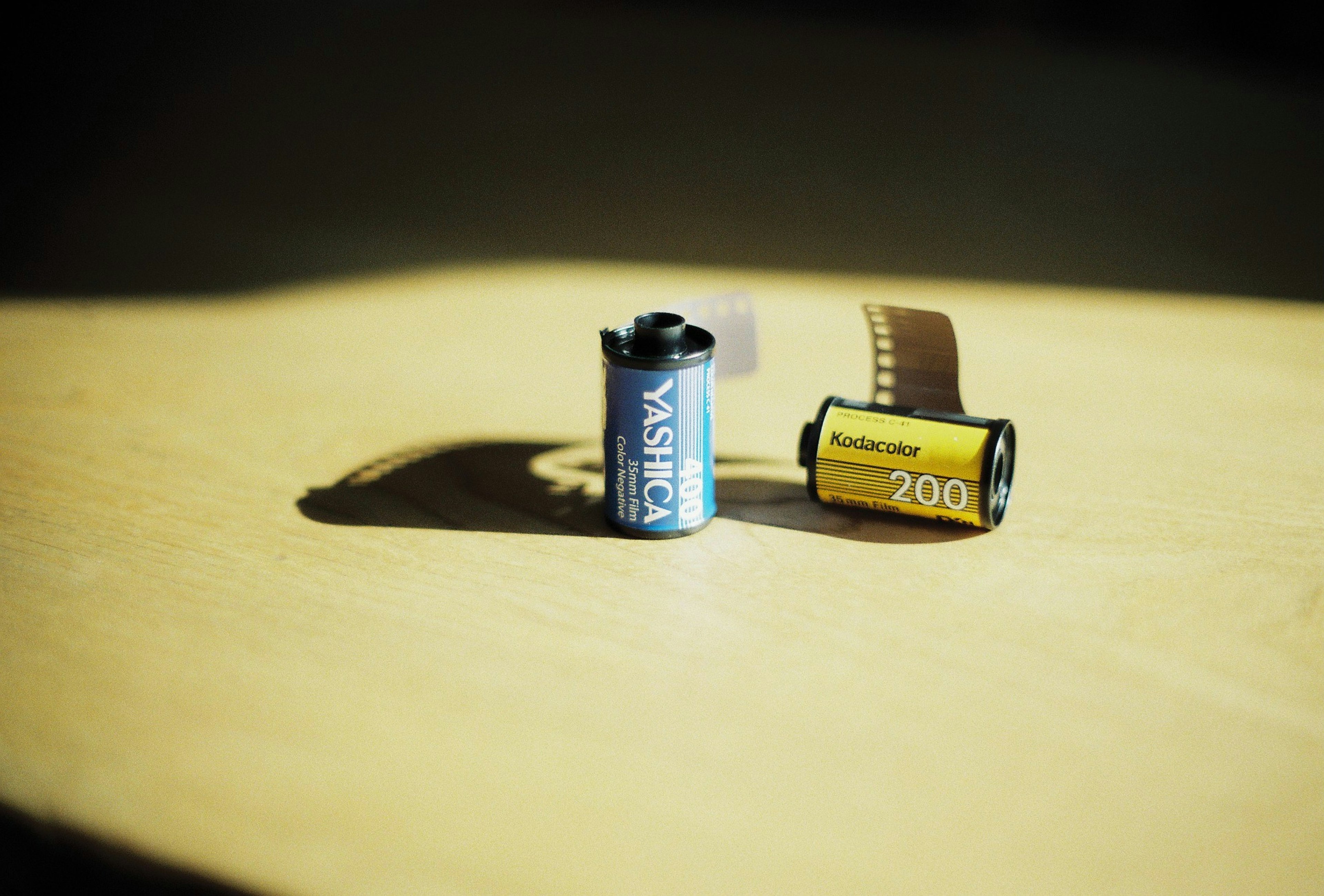 Cartuchos de película azul y amarilla colocados sobre una mesa de madera