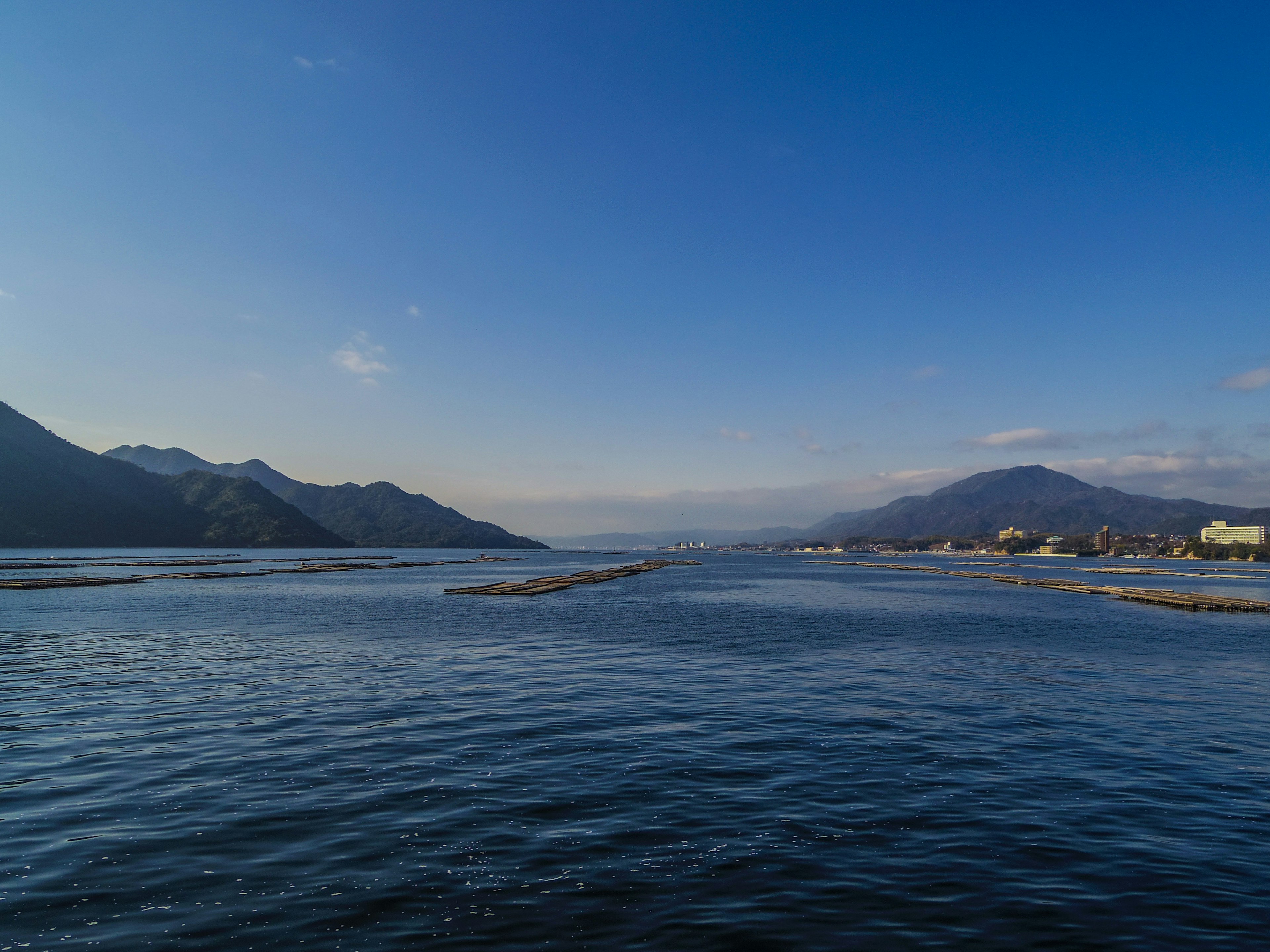 Vista escénica de un río con cielo azul y montañas al fondo