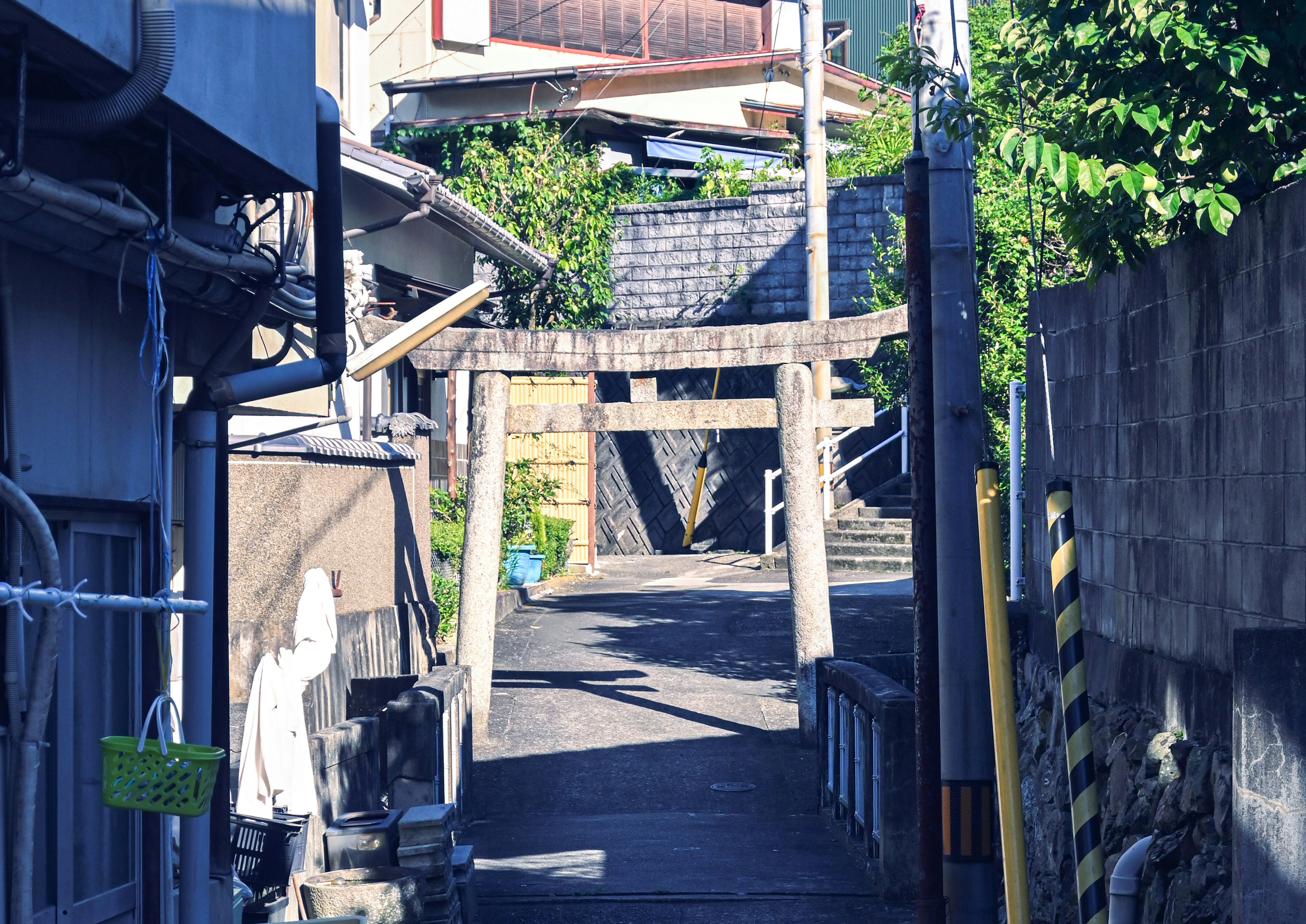 Vicolo stretto con un cancello torii e edifici circostanti