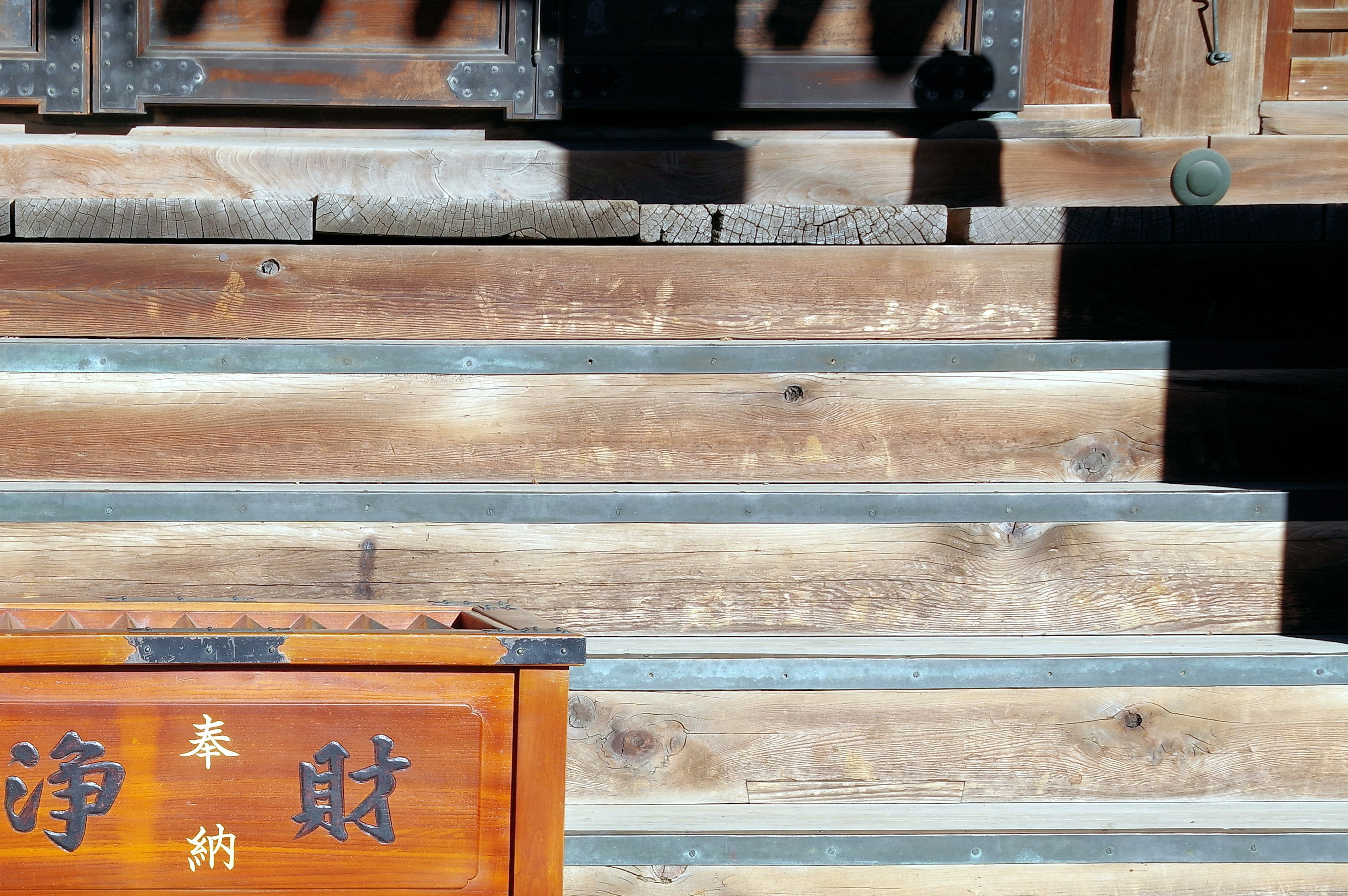 木製の階段と箱がある神社の風景