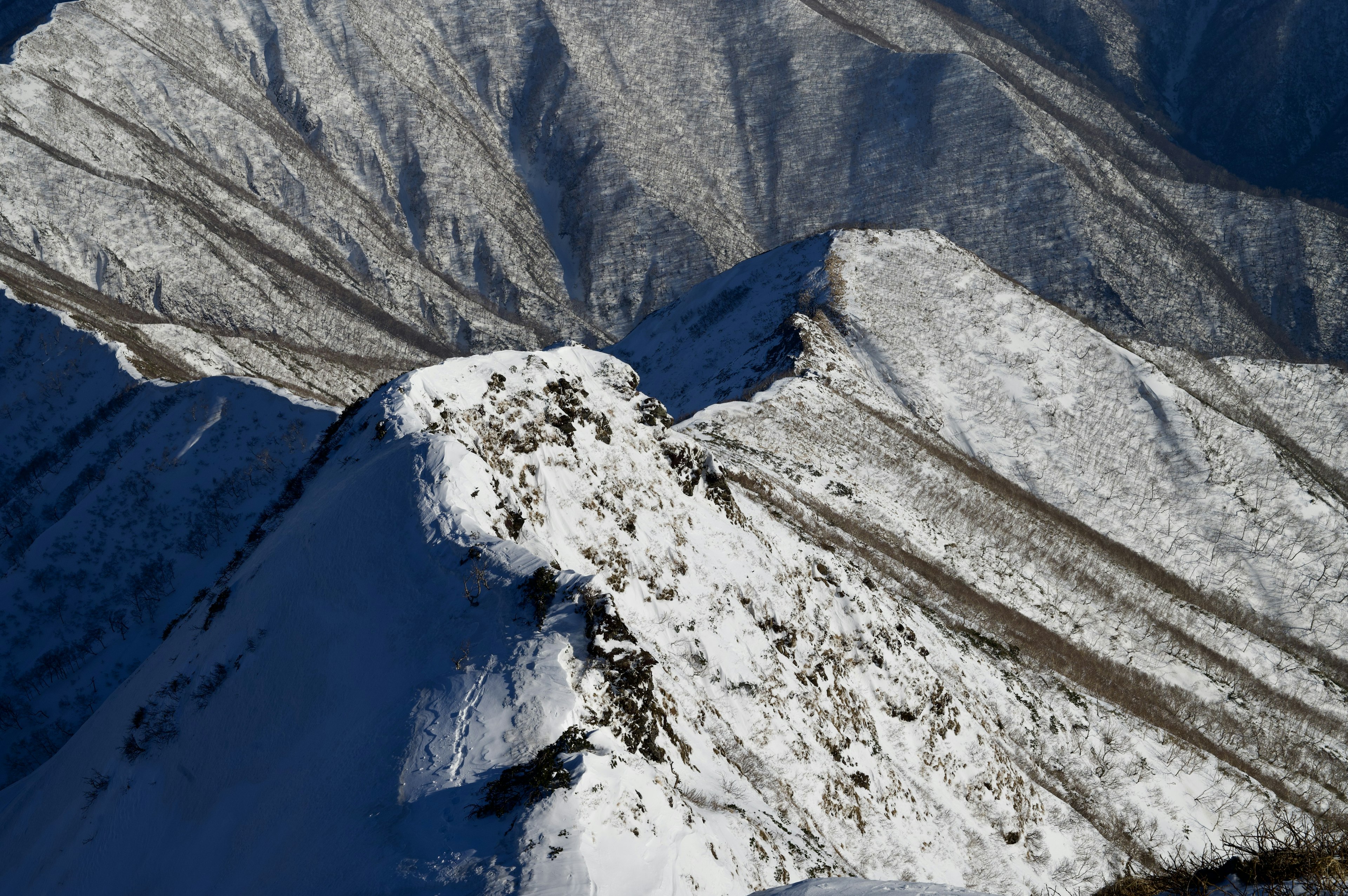 Picco di montagna coperto di neve con pendii ripidi