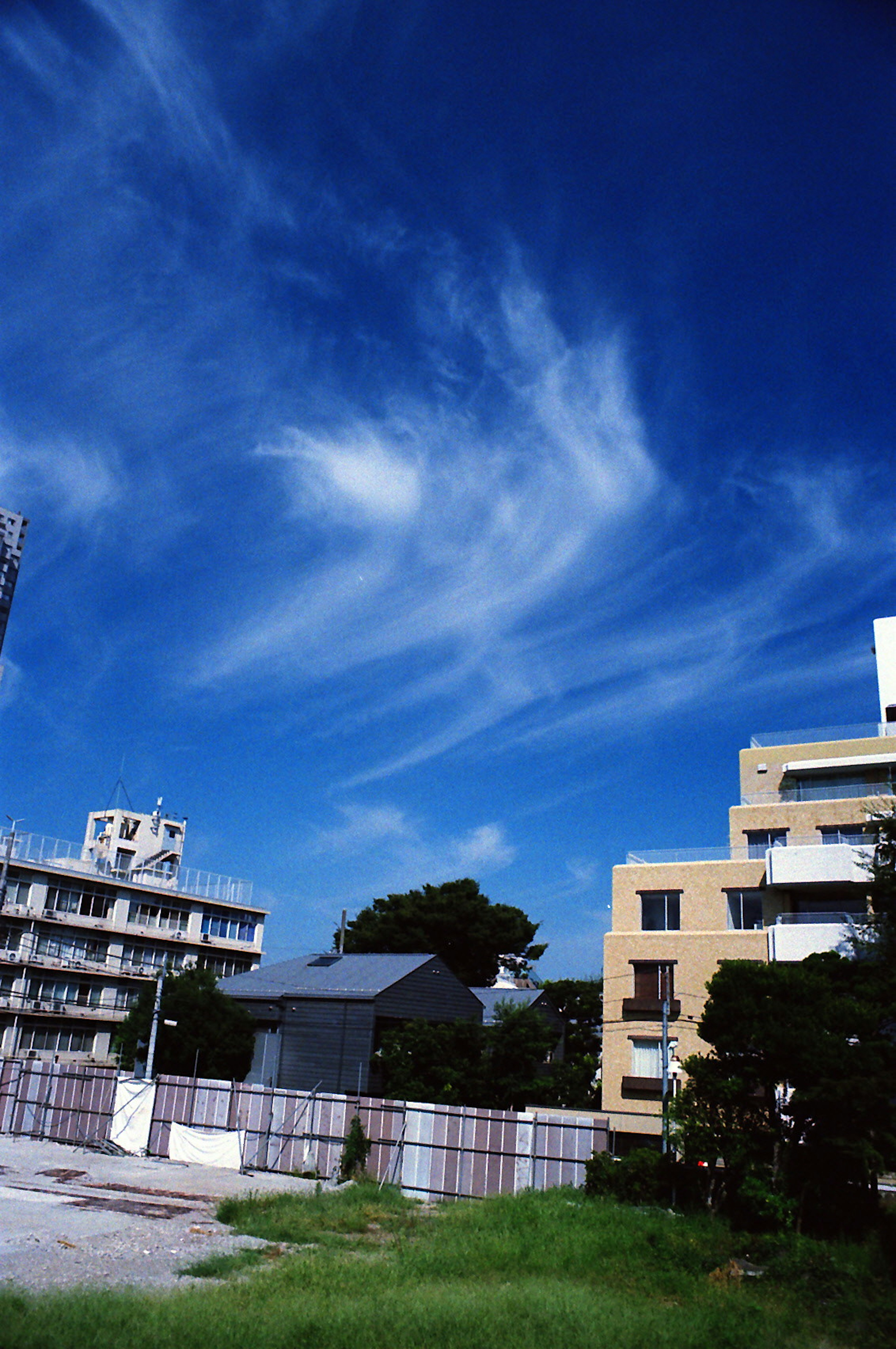 Paysage urbain avec ciel bleu et nuages blancs, bâtiments à proximité visibles