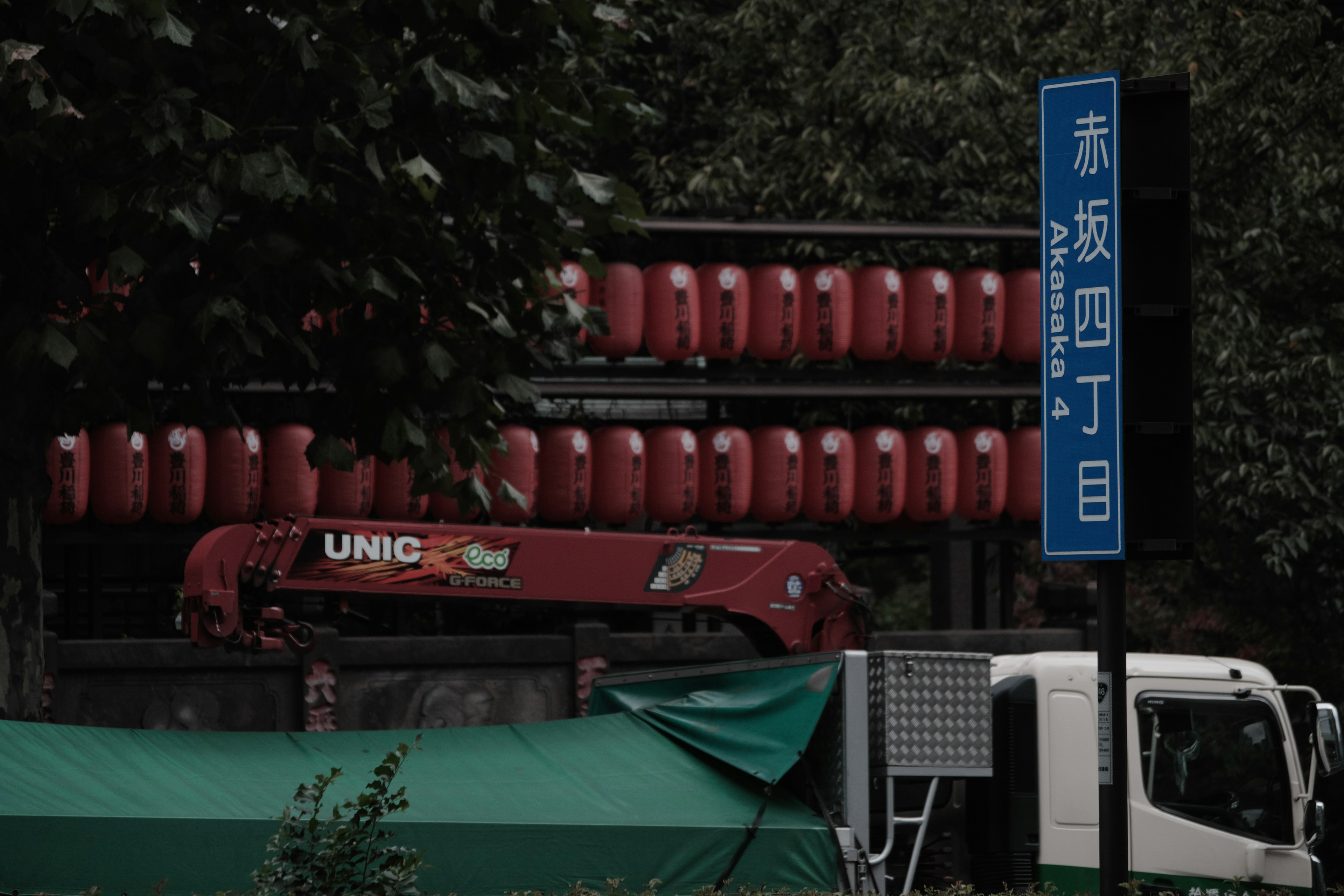 Esquina de la calle con tanques rojos visibles en un edificio y un camión verde