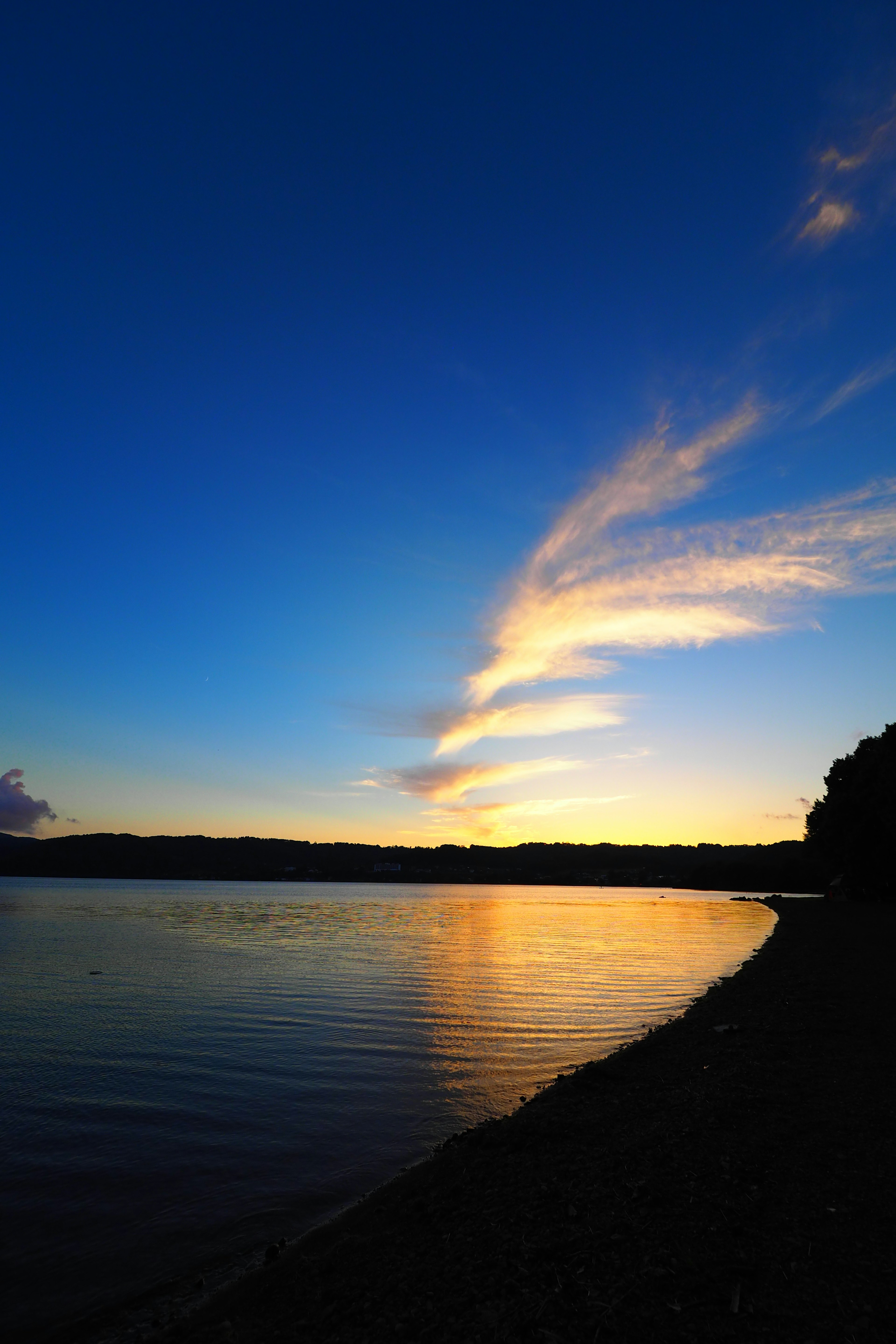 Landschaftsansicht eines Sonnenuntergangs mit bunten Wolken, die sich im Wasser spiegeln