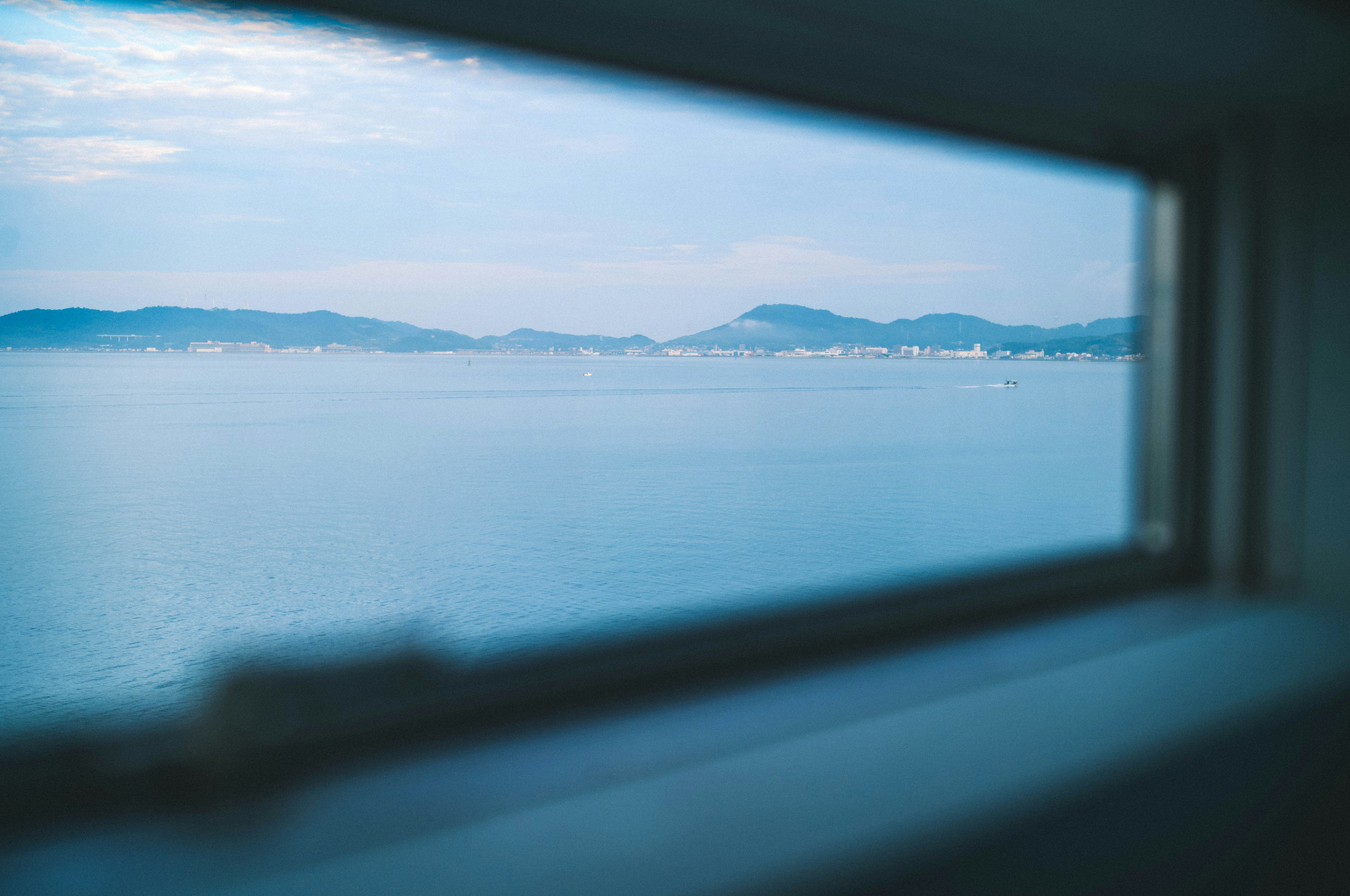 窓から見える青い海と山の風景